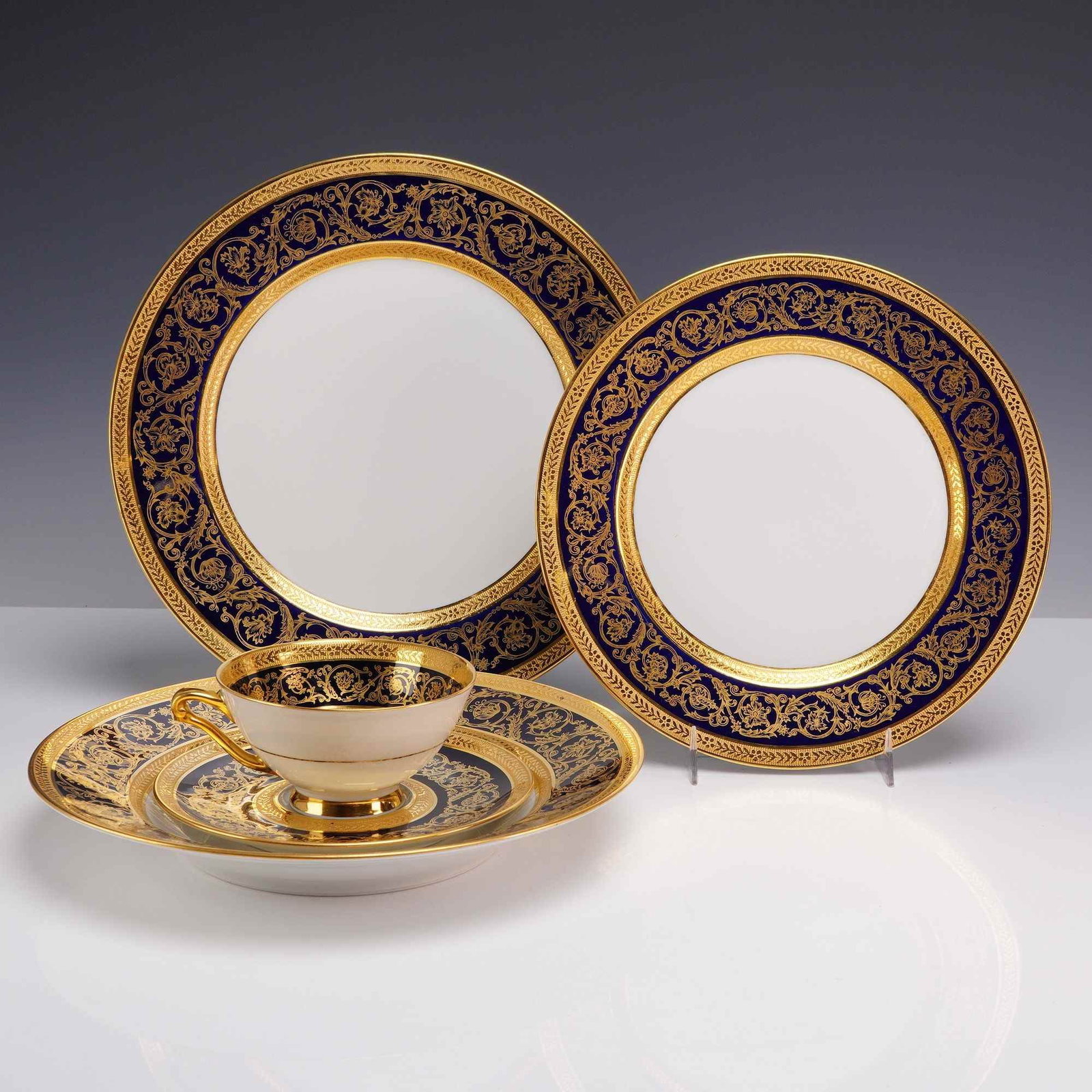 5pc C. H. Field Haviland Limoges China Set with Double Dorure: This five-piece porcelain place setting was manufactured by C. H. Field Haviland in Limoges, France. The set includes a dinner plate, salad plate, bowl, teacup, and saucer. The pieces feature a neocla