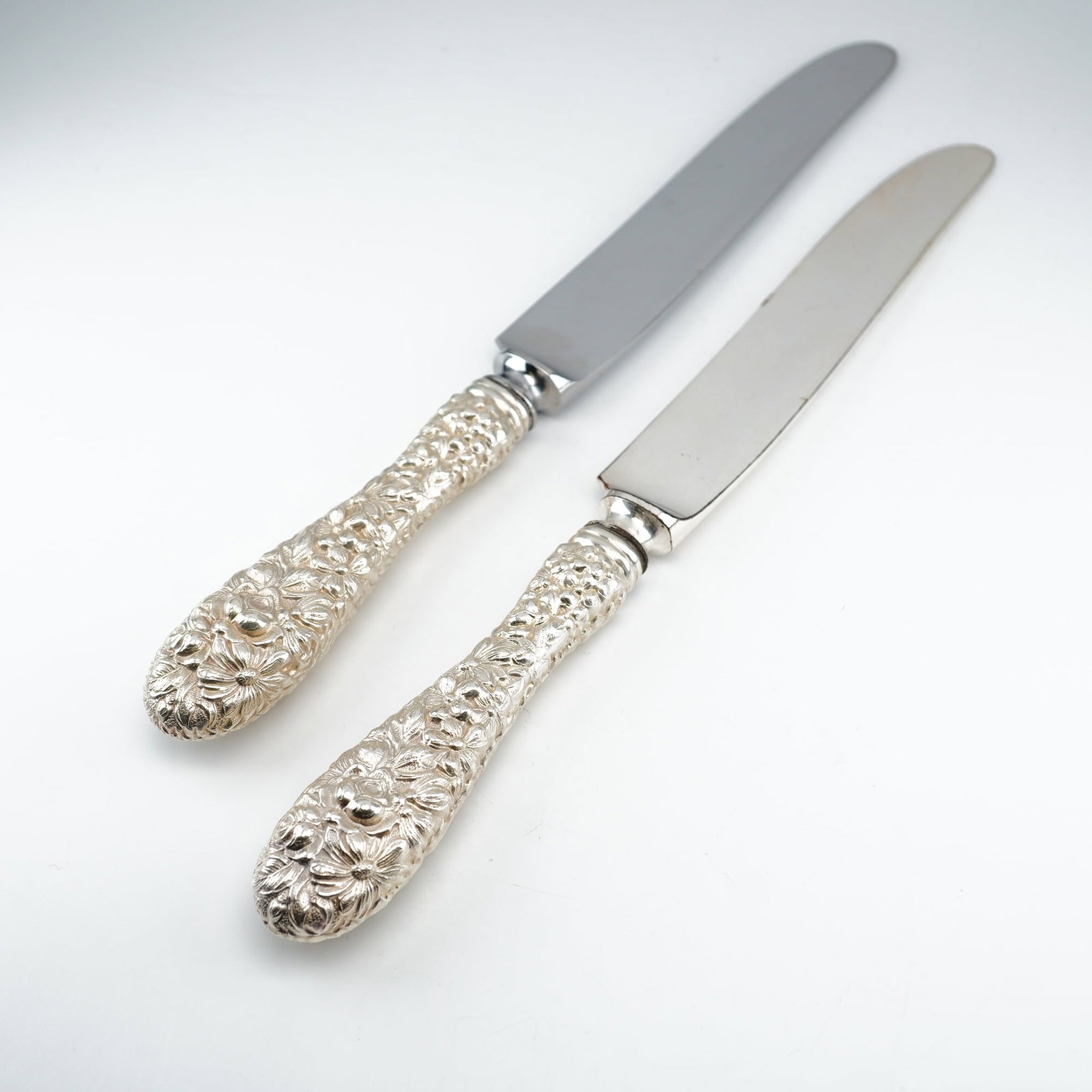 2pc Kirk Stieff Sterling Silver and Stainless-Steel Dinner Knives, Stieff Rose: Pair of dinner knives crafted in the classic Stieff Rose pattern by Kirk Stieff, a design dating back to 1892. Each piece features an intricately detailed sterling silver handle with floral repousse o