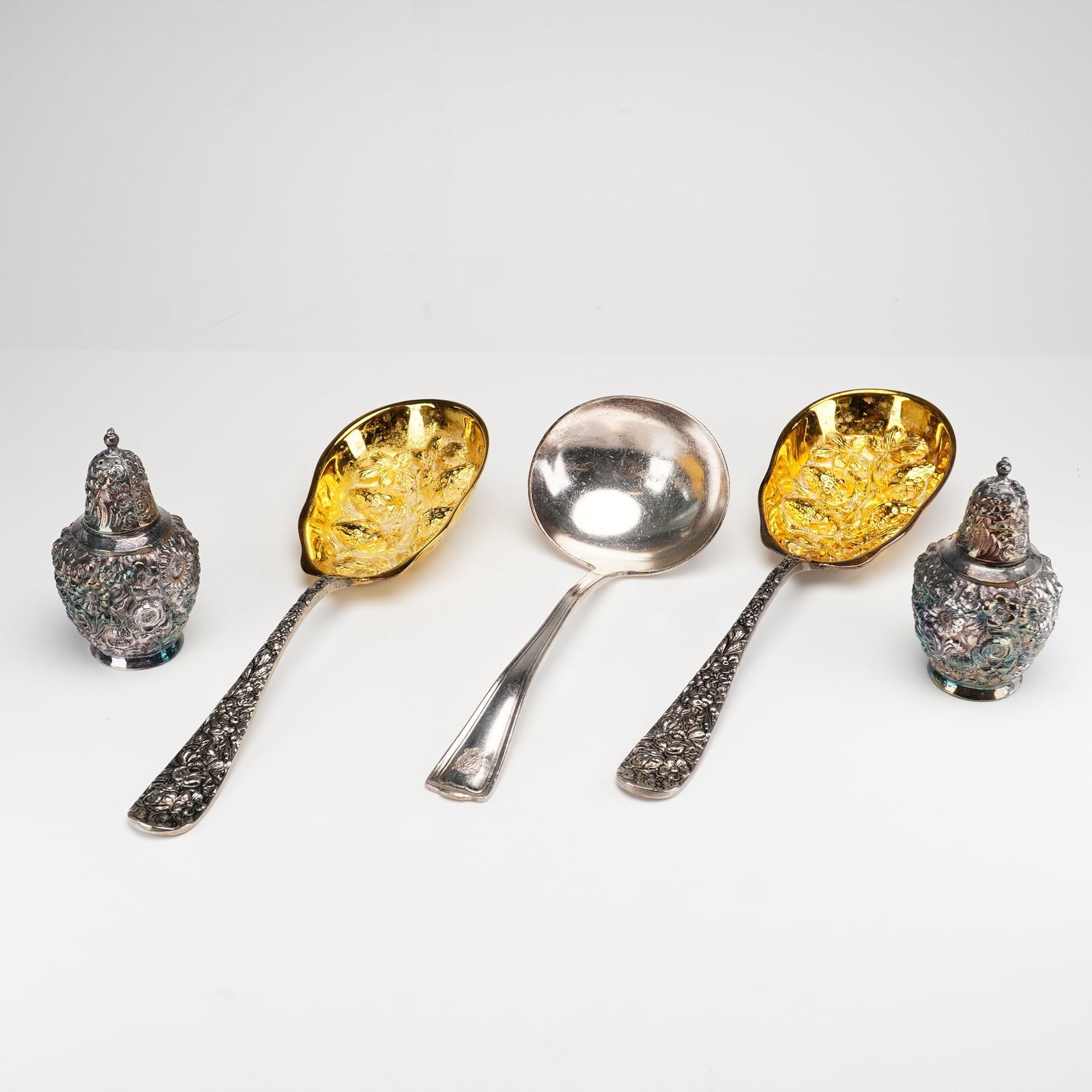 5pc Silver-Plated and Gold-Plated Foliate Motif Serving Utensils and Shaker Set: Collection includes a pair of silver-plated salt and pepper shakers by W.B. M.F.G. Co. for Weidlich Brothers Manufacturing Company, each decorated with foliate motifs. Also included is a pair of Godin
