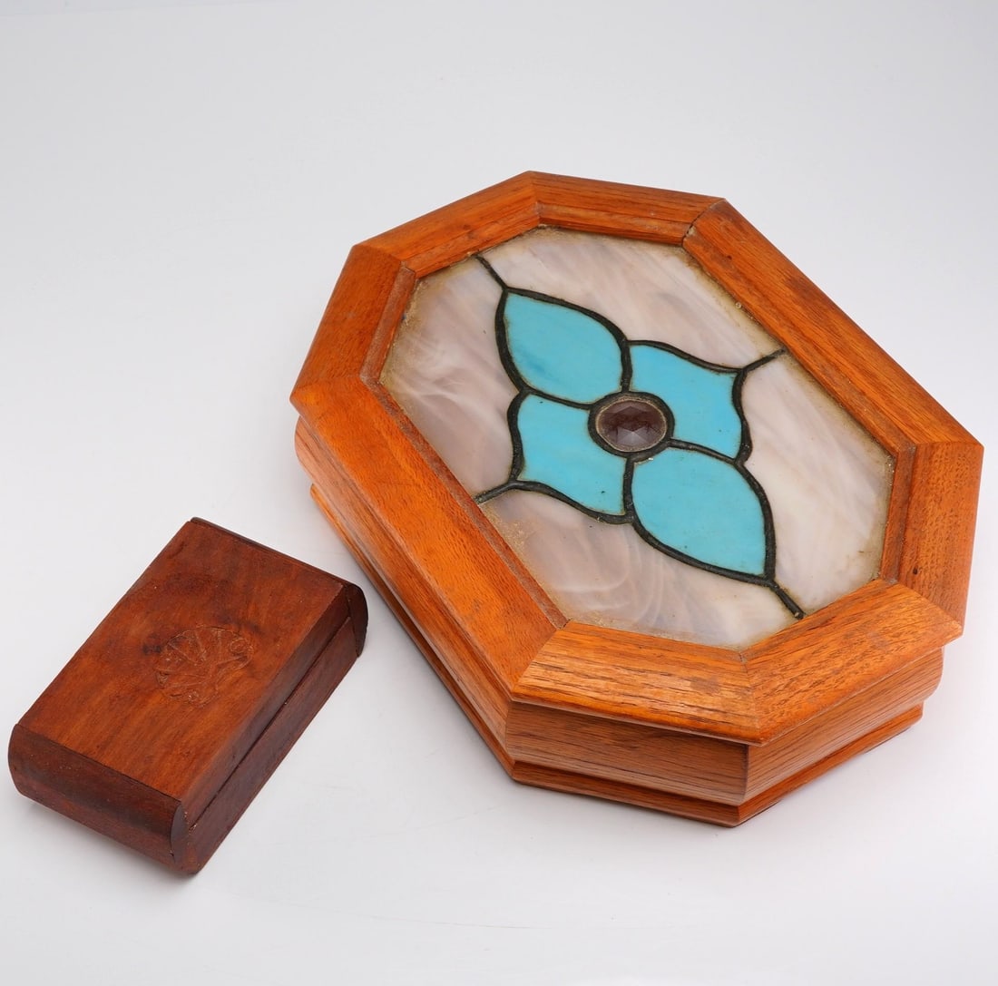 Two Wooden Lidded Boxes: This collection consists of two wooden lidded boxes, with one having a stained glass window. The large octagonal box is constructed of light-toned wood, featuring a hinged lid inset with a stained