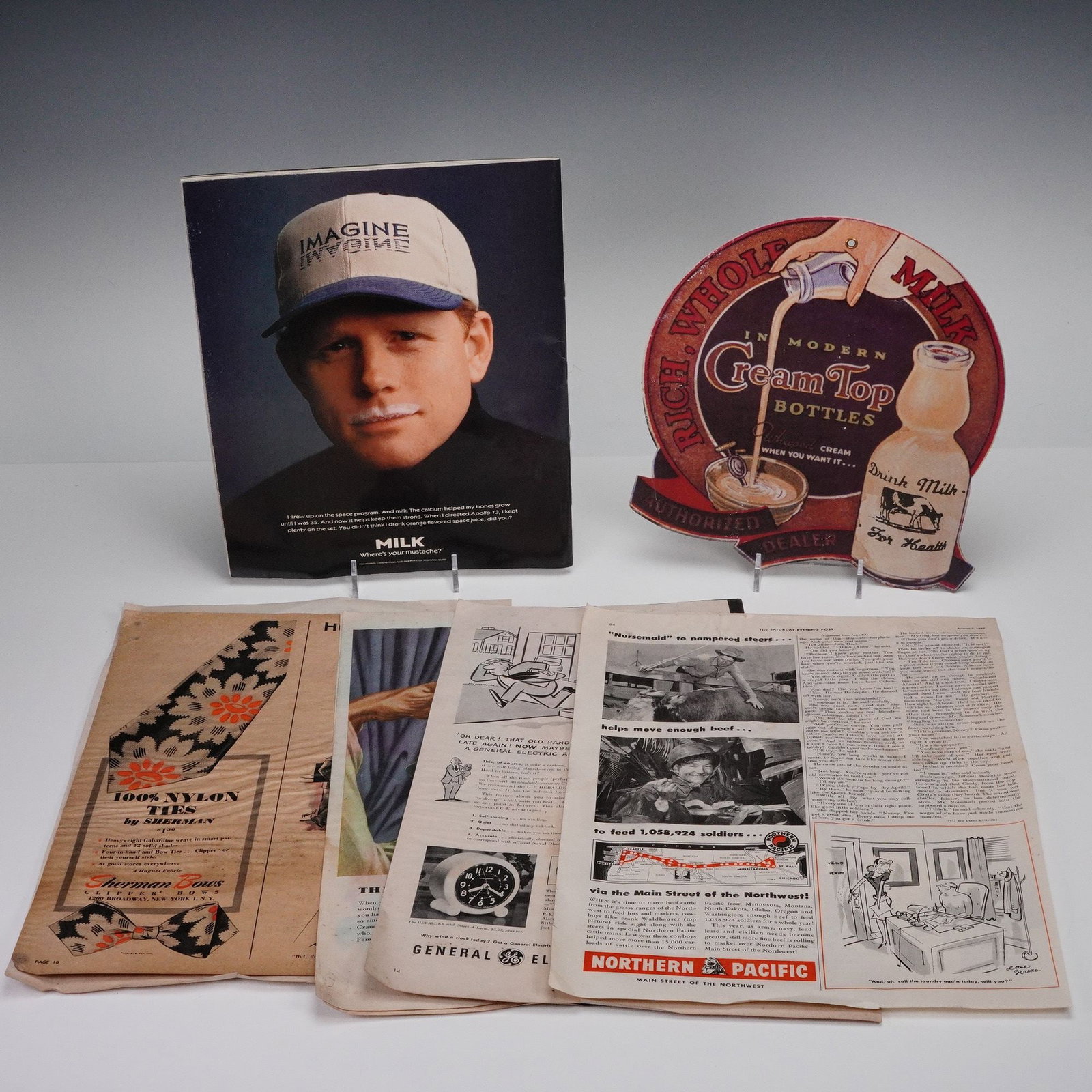 8pc Collection of Vintage Advertising & Magazine Memorabilia, 1940s: Group of early advertising and magazine memorabilia including original 1946 and 1949 magazine pages featuring automotive, travel, and consumer product ads, a vintage die-cut "Cream Top Milk" sign,