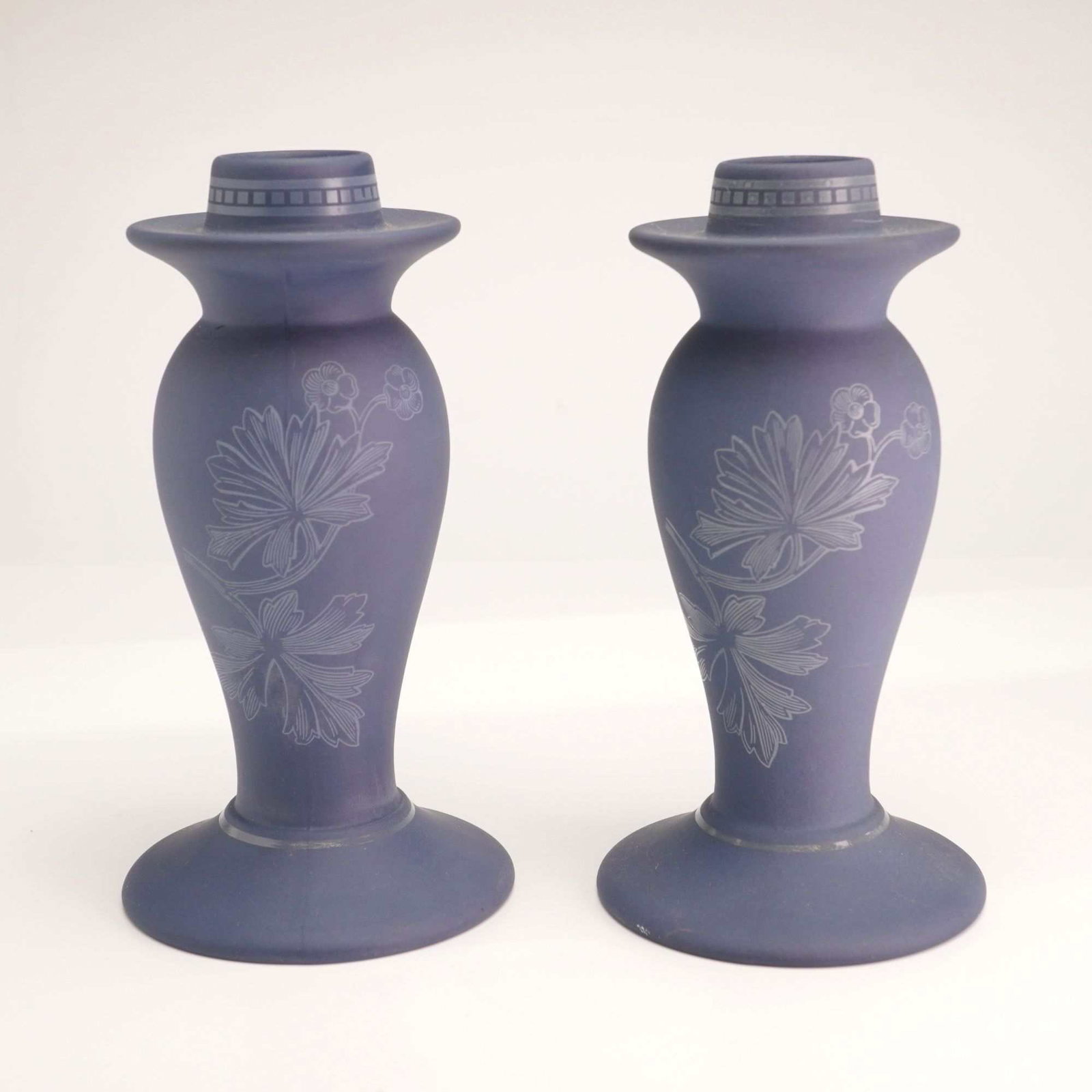 Pair of Wedgwood Interiors Collection Blue Jasperware-Style Candlestick Holders: This pair of Wedgwood candlesticks from the Interiors collection is crafted from matte-finished blue stoneware. Each candlestick features a tapered baluster form with a wide circular base and a flared