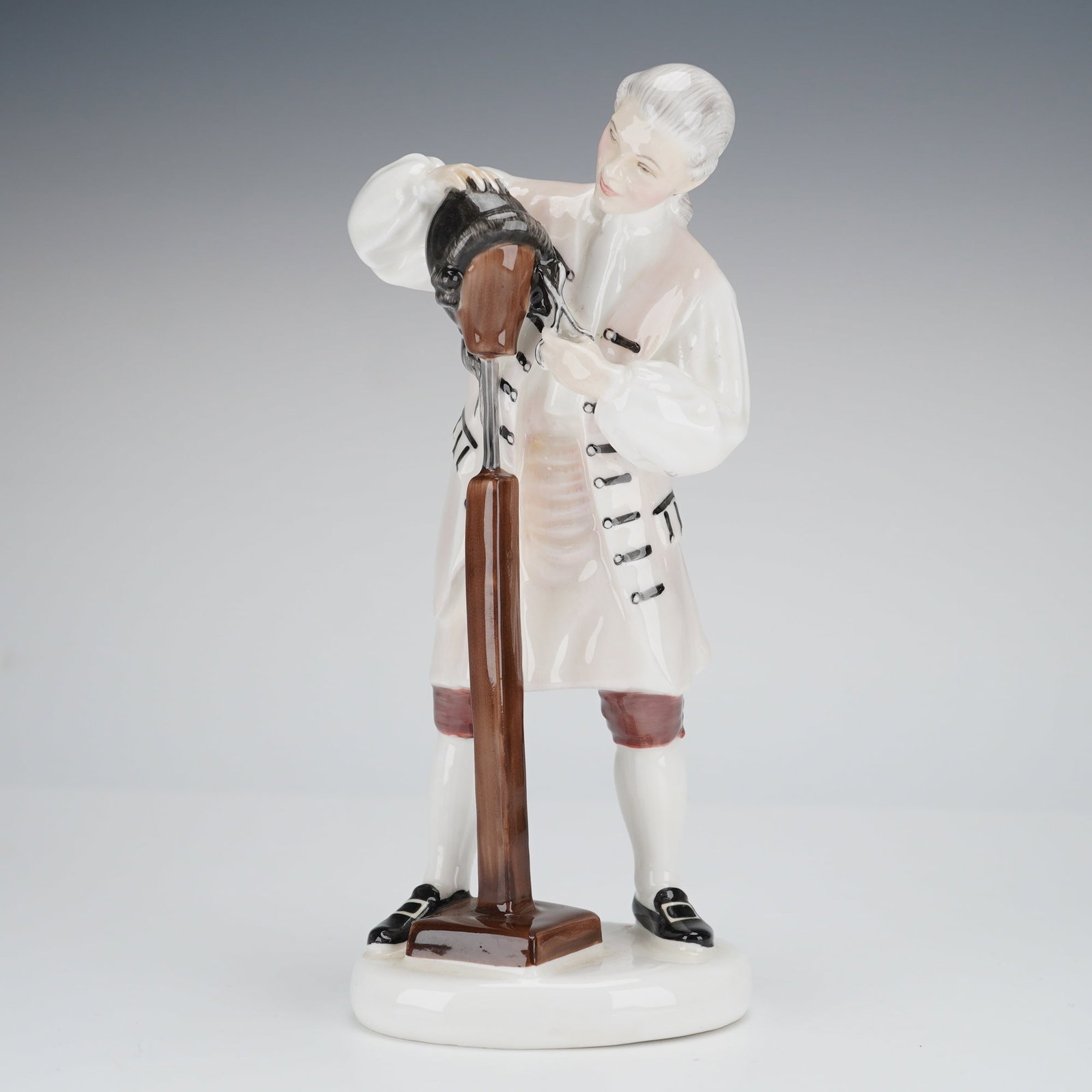 Royal Doulton Bone China Figurine Wigmaker of Williamsburg HN2238: A single bone china figurine by Royal Doulton, titled The Wigmaker of Williamsburg, model number HN 2238. The figurine depicts a standing male figure dressed in 18th-century style attire, including a 