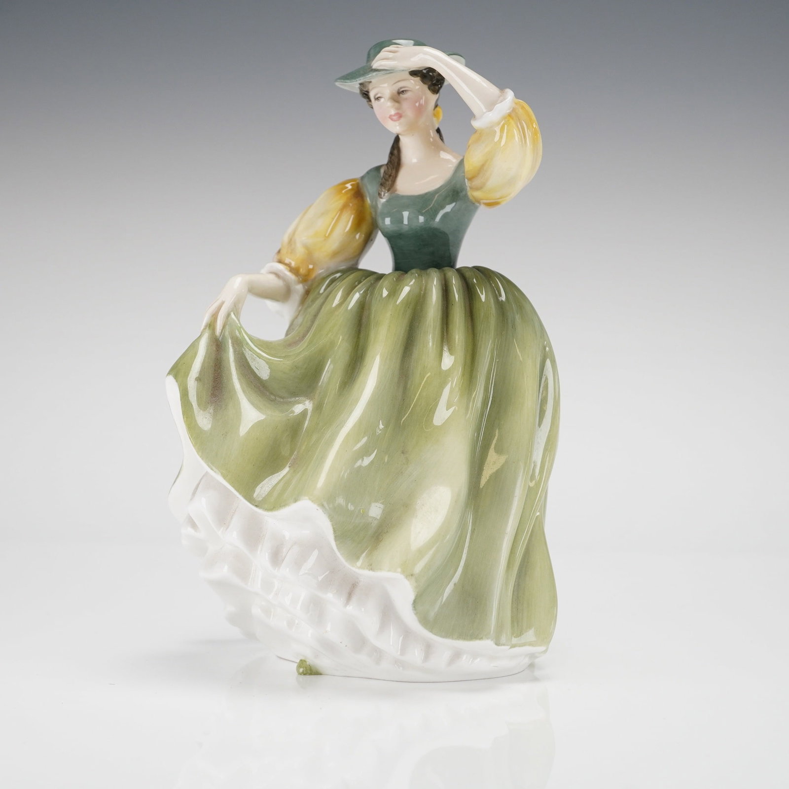 Royal Doulton Buttercup HN 2309 Bone China Figurine: A single Royal Doulton bone china figurine, model Buttercup HN 2309. The figurine depicts a young woman in 20th-century rustic attire, featuring a green bodice, yellow puffed sleeves, and a sweeping g