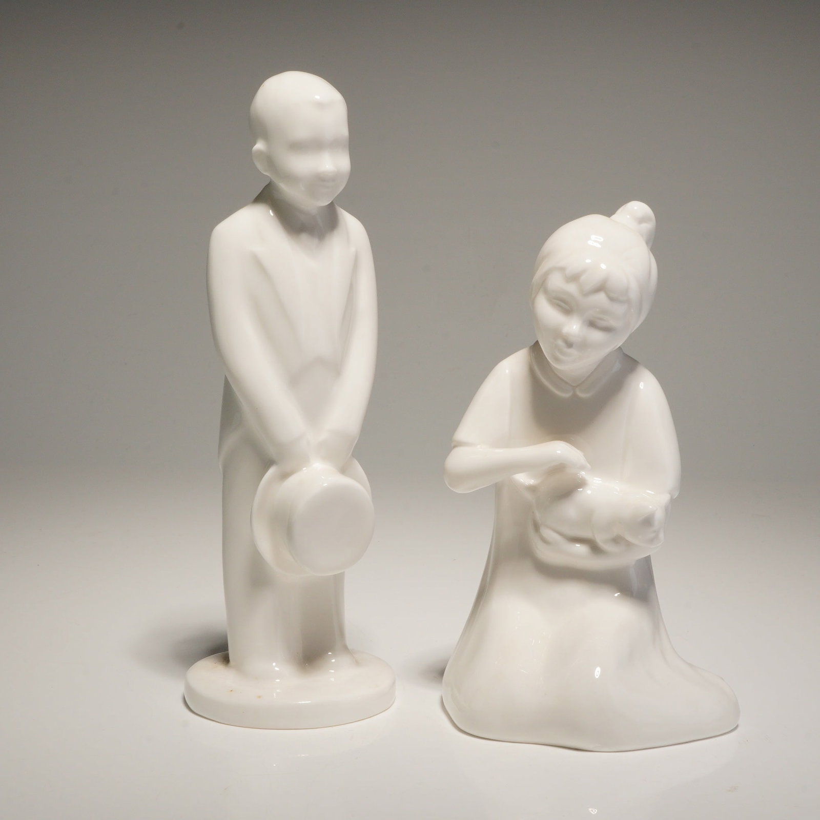 2pc Coalport Moments Bone China Figurines, The Pageboy and I Love You: A pair of monochromatic white glazed bone china figurines from the Moments by Coalport collection. The first figure is titled The Pageboy and depicts a standing male in formal attire holding a top
