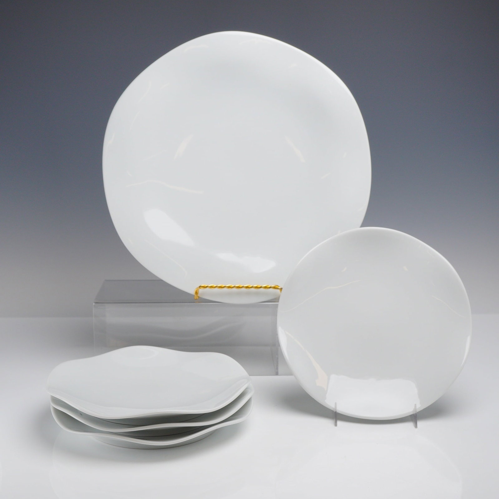 Set of Five Medard de Noblat Limoges Porcelain Plates, Gala Pattern: The pieces feature a minimalist aesthetic with contemporary, organic shapes characterized by soft, undulating rims. The porcelain is undecorated, emphasizing the sculptural form and the material quali