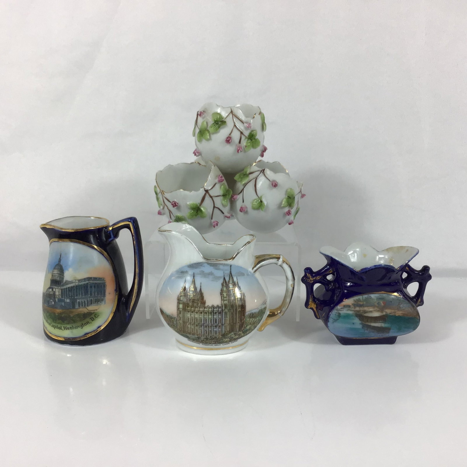 4pc German Porcelain Souvenir Ware and Miniature Vessels: This collection of German porcelain includes several souvenir items and decorative miniatures dating from the early to mid-20th century. The assortment features a small single-handled pitcher with a
