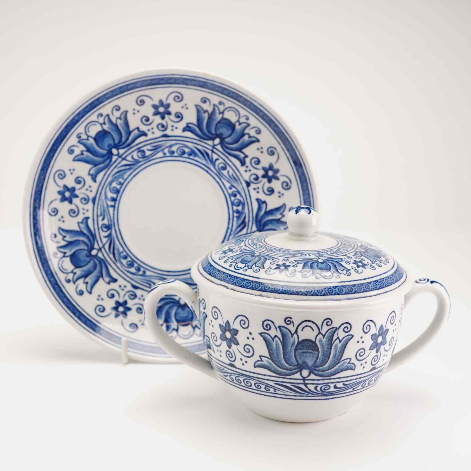 Wedgwood Magnolia Pattern Cup with Handles, Lid, and Saucer: This set consists of two Wedgwood Magnolia pattern items and one lid, including a bouillon cup with handles and a matching saucer. The pieces are crafted from glazed earthenware and feature the Magnol