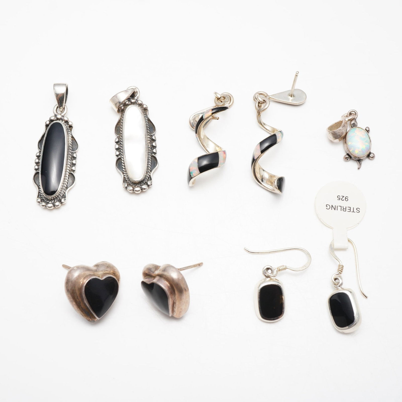 9pc Sterling Silver and Gemstone Jewelry Group Including 3 Pair of Earrings and 3 Pendants: This collection includes nine pieces of sterling silver jewelry featuring black onyx and iridescent stone accents. The group consists of three pendants and three matched pairs of earrings. The first p
