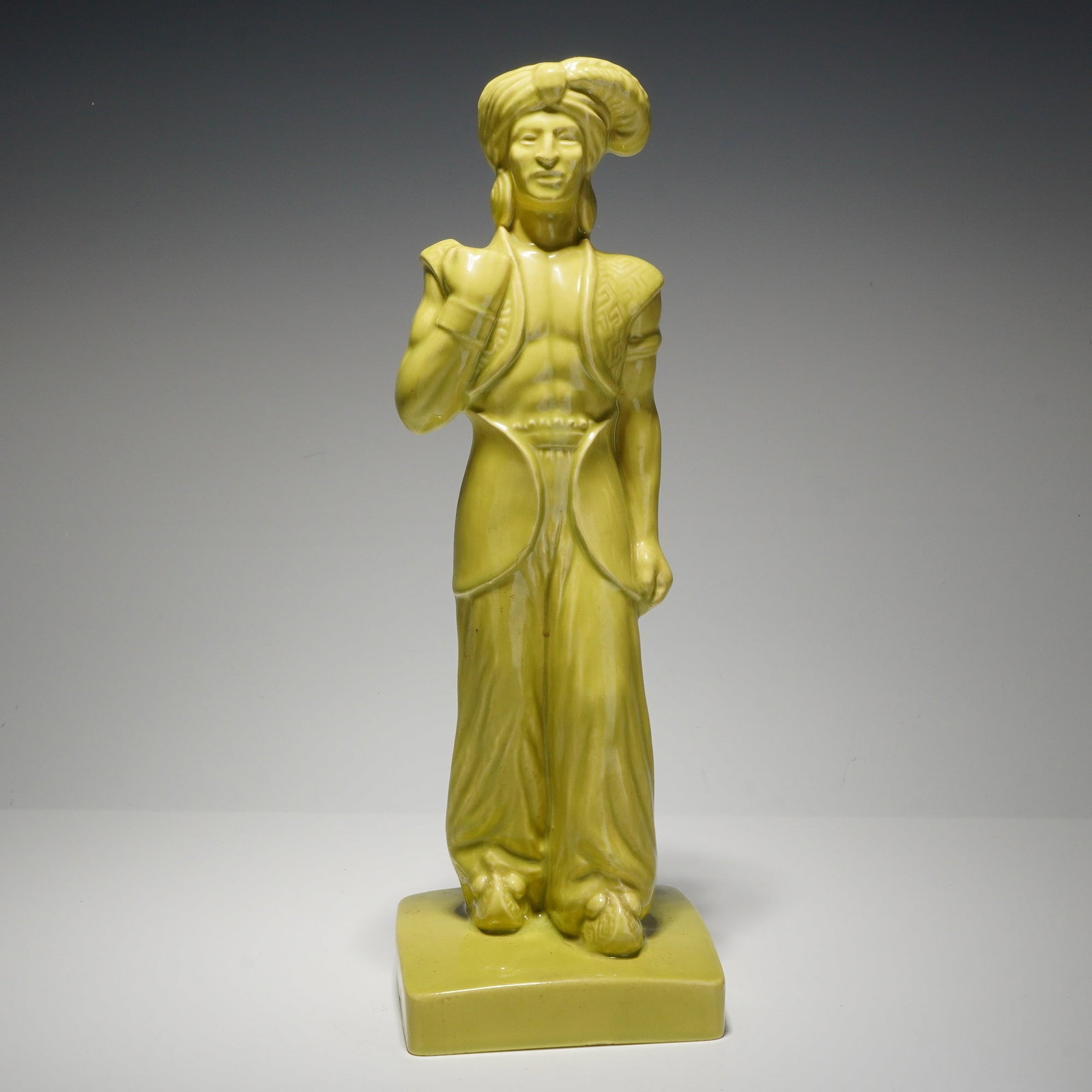 Gonder Ceramic Arts, Mid-Century Modern Orientalist Page Figurine: This mid-century modern stylized ceramic figurine was produced by Gonder Ceramic Arts and is dated 1950. The piece depicts a standing male figure in Middle Eastern-inspired attire, featuring a large t