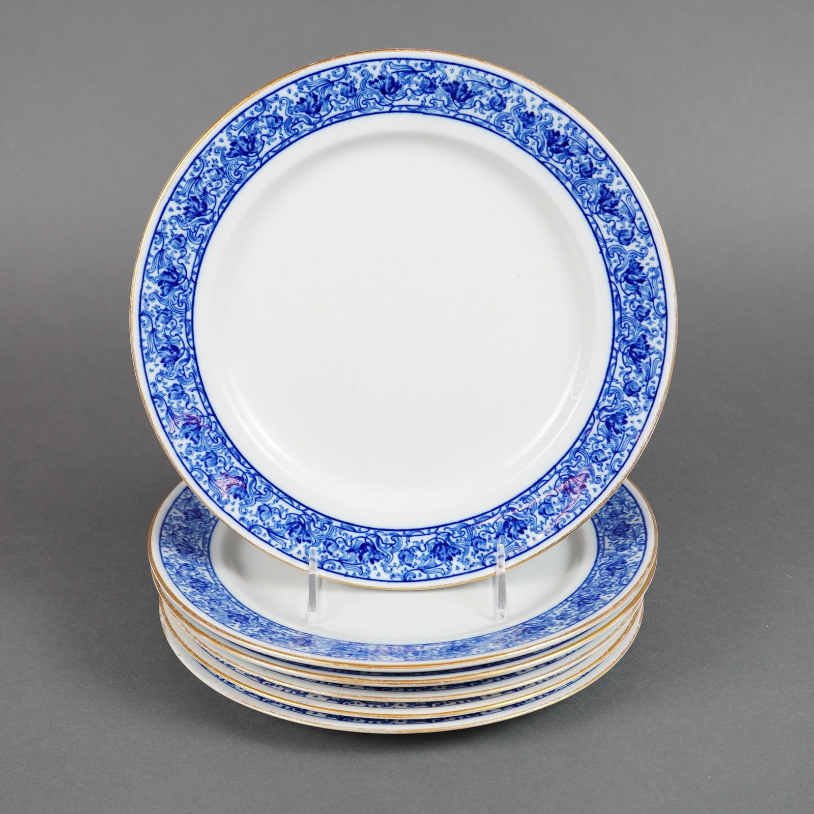 6pc Royal Worcester Vitreous Blue and Gilt Dinner Plates: Dinner plates, featuring a blue and white foliate border pattern accented with gilt edging. The design incorporates a broad band of highly detailed scrolling floral motifs around the rim, leaving the