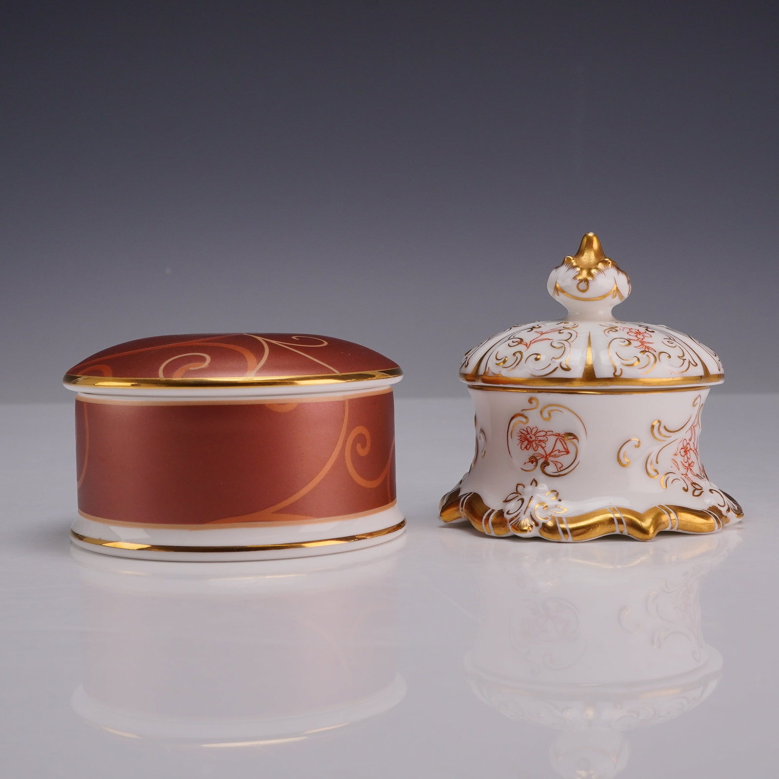 A Lot of Two Wedgwood Bone China Trinket Boxes, Marrakech and Crown Shape Patterns: This lot consists of two lidded bone china boxes produced by Wedgwood in England. The first item is in the Marrakech pattern, featuring a cylindrical form with a low-domed lid. The exterior is decorat