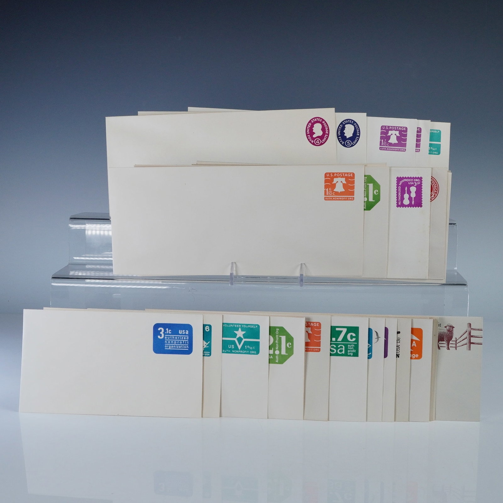 30pc Vintage US Postal Stationery Envelopes: Collection of thirty vintage United States postal stationery envelopes with pre-printed postage in assorted denominations and designs. Includes colorful examples featuring motifs such as the Liberty