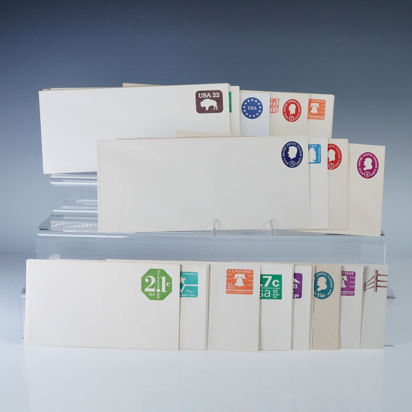 30pc Vintage US Postal Stationery Envelopes: Collection of thirty vintage United States postal stationery envelopes with pre-printed postage in assorted denominations and designs. Includes colorful examples featuring motifs such as the Liberty