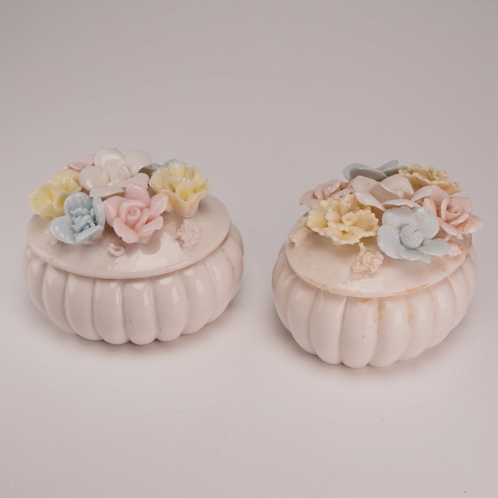 2pc Lenwile Ardalt Verithin Porcelain Floral Trinket Boxes: This pair of porcelain trinket boxes was produced for the Lenwile line by Ardalt in Japan. Each box features an oval form with a gadrooned or melon-lobed base finished in a high-gloss white glaze.