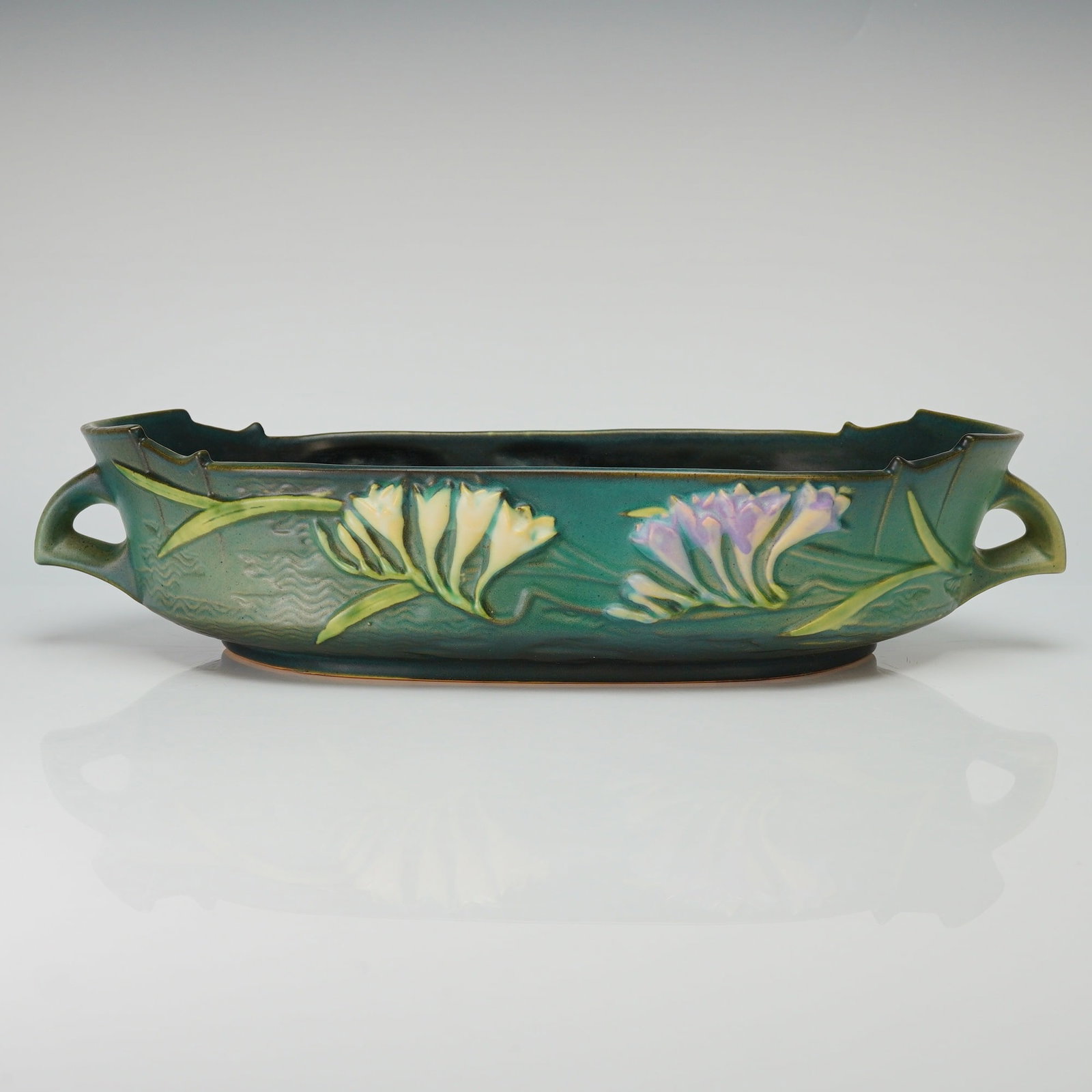 Roseville Pottery Green Console Bowl, Freesia: A mid-20th century American art pottery console bowl produced by the Roseville Pottery Company of Zanesville, Ohio. This vessel is presented in the Freesia pattern, which was first introduced in 1945.