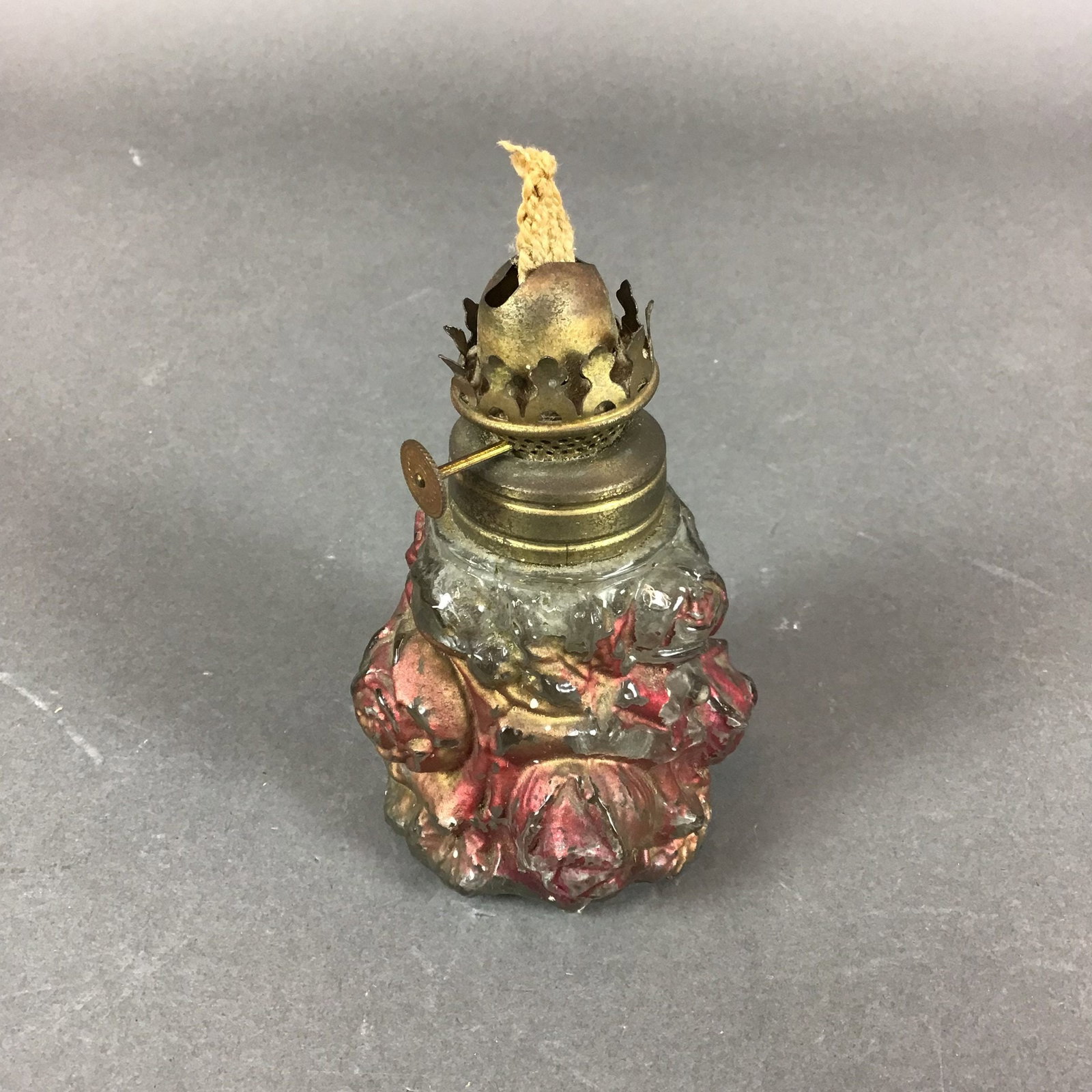 Victorian Style Miniature Molded Glass Rose Pattern Oil Lamp: A Victorian-style miniature oil lamp featuring a molded clear glass font. The body is designed with high-relief rose and leaf patterns. The floral motifs are decorated with red and gold-tone cold-pain