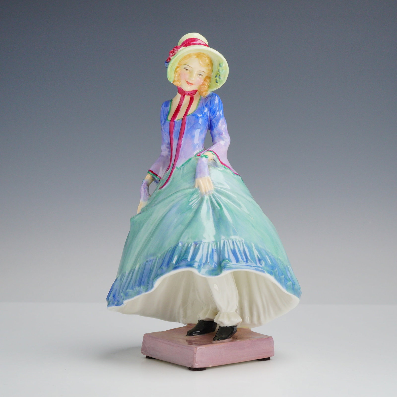 Royal Doulton Bone China Figurine Pantalettes HN 1362: A hand-painted glazed bone china figurine titled Pantalettes, model number HN 1362, produced by Royal Doulton in England. The figure depicts a young woman in stylized nineteenth-century attire. She is