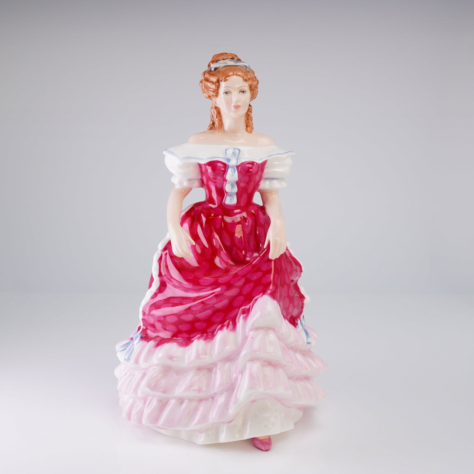 Royal Doulton Figurine Sweet Sixteen HN3648: A glazed porcelain figurine by Royal Doulton, titled 'Sweet Sixteen,' model HN3648. The piece is constructed of English bone china and is hand-painted. The figurine depicts a standing woman dressed in