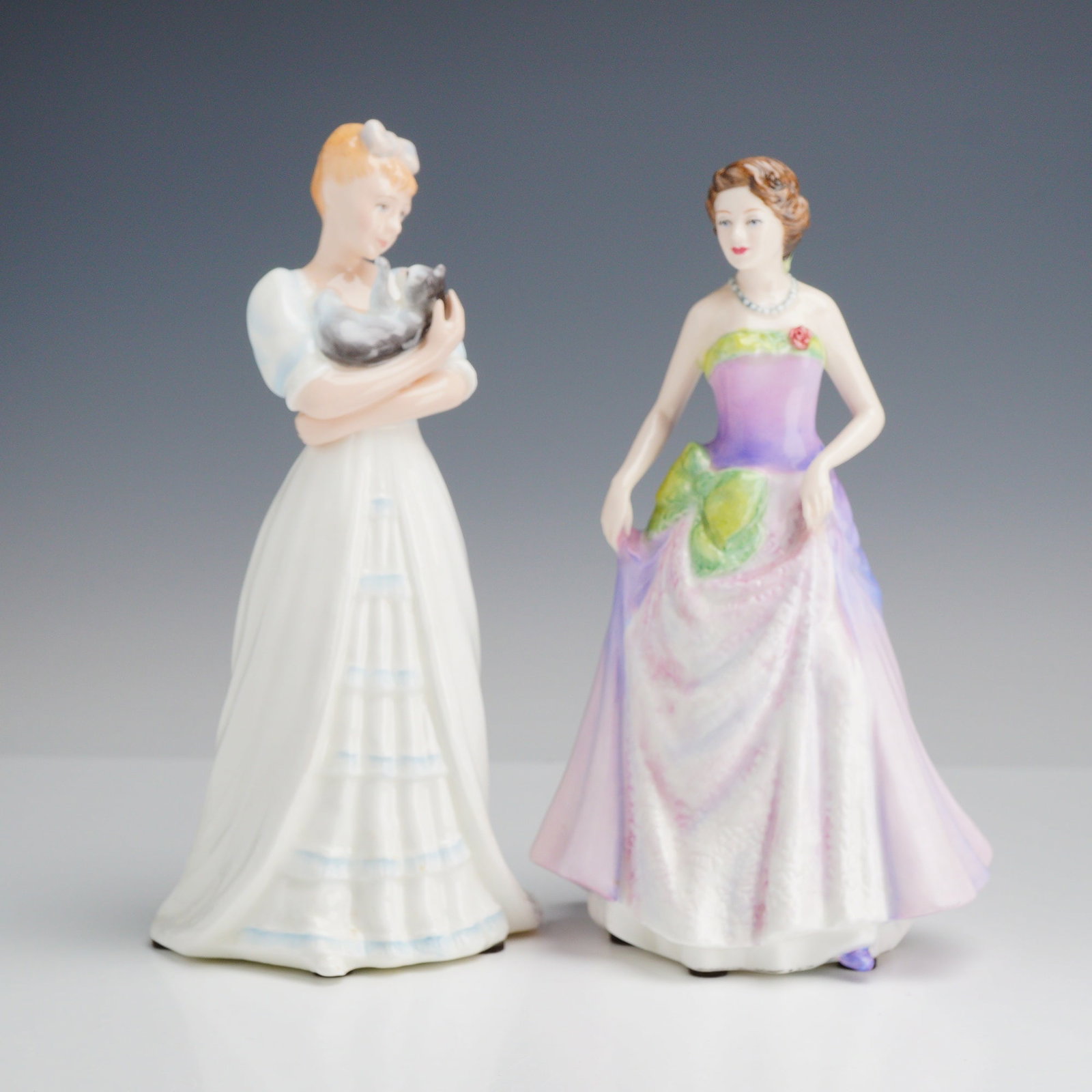 Two Royal Doulton Figurines, Kimberley HN 3379 and Jessica HN 3850: This lot features two Royal Doulton glazed bone china figurines. The first figurine, titled Kimberley (HN 3379), was modeled by Timothy Potts and issued in 1992. It depicts a woman with blonde hair in