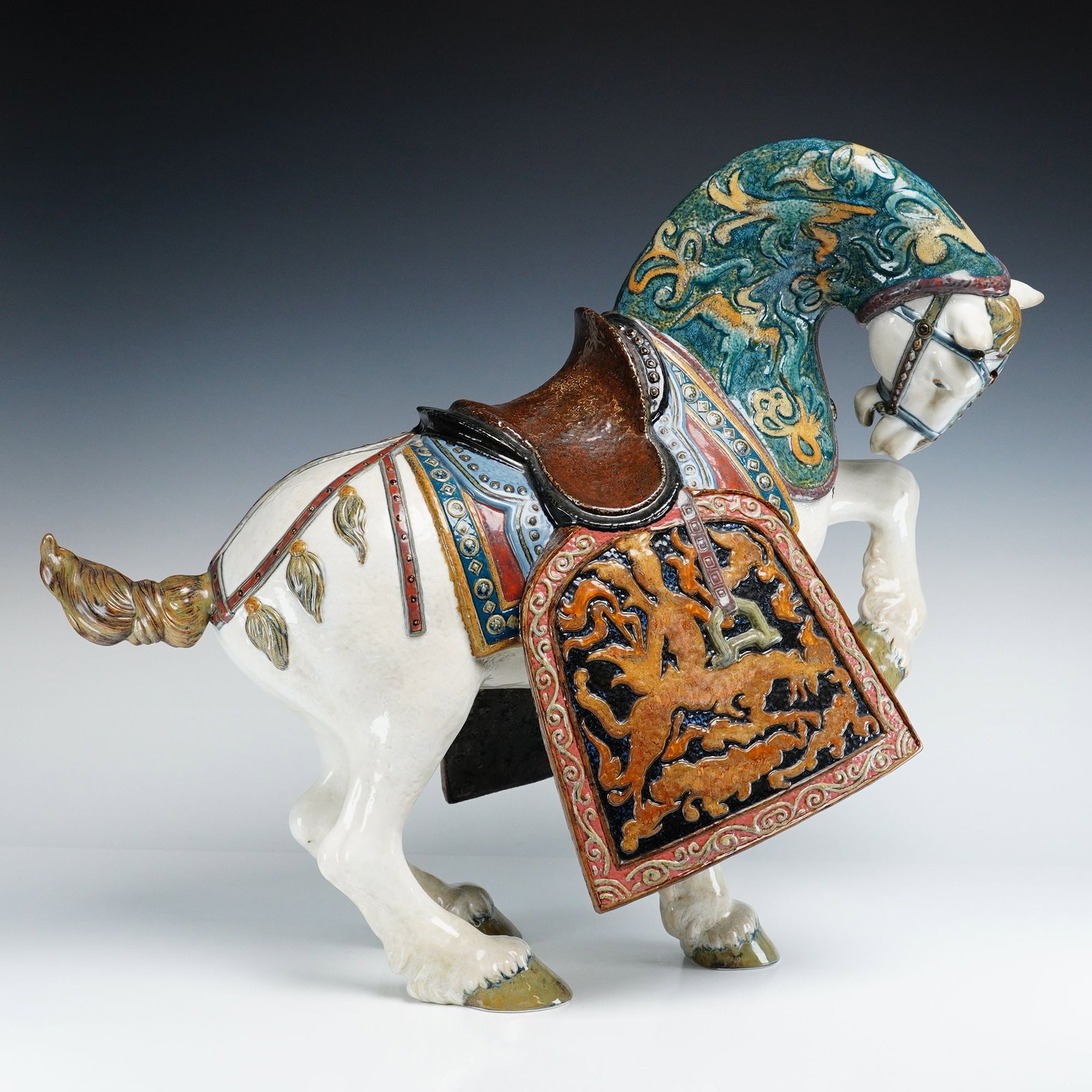 Lladro High Porcelain Sculpture, Oriental Horse 1001943: Limited edition Lladro Oriental Horse figurine, modeled after equestrian sculptures of China's Tang Dynasty. Crafted in high-gloss porcelain, the figure is decorated with turquoise, brown, and ochre e