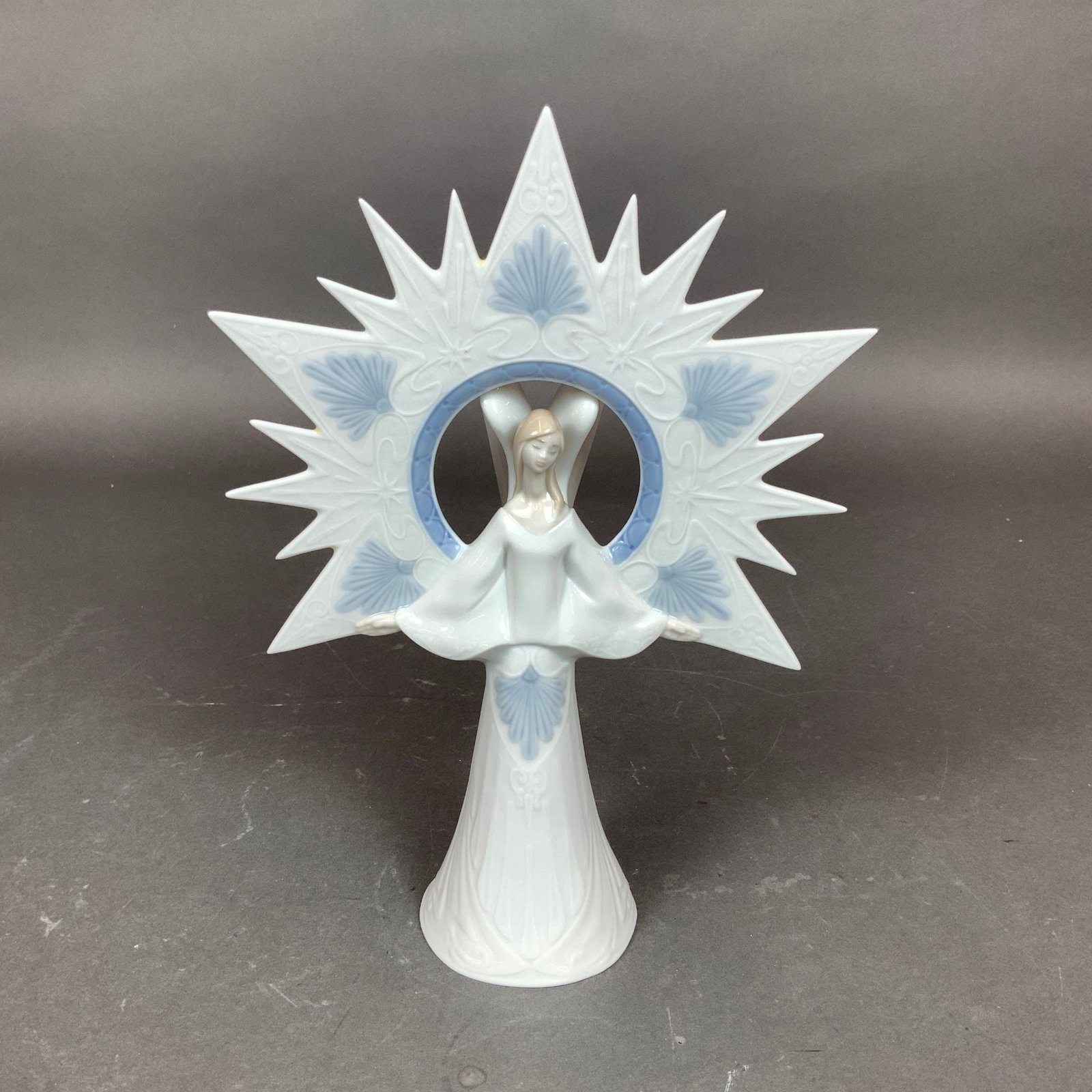 Lladro Porcelain Figurine Tree Topper, Angel of Light 01006501: This Lladro glazed porcelain figurine, titled Angel of Light (Angel de la Luz) and cataloged as model number 6501, depicts a slender angel with arms outstretched in front of a large fourteen-point sta