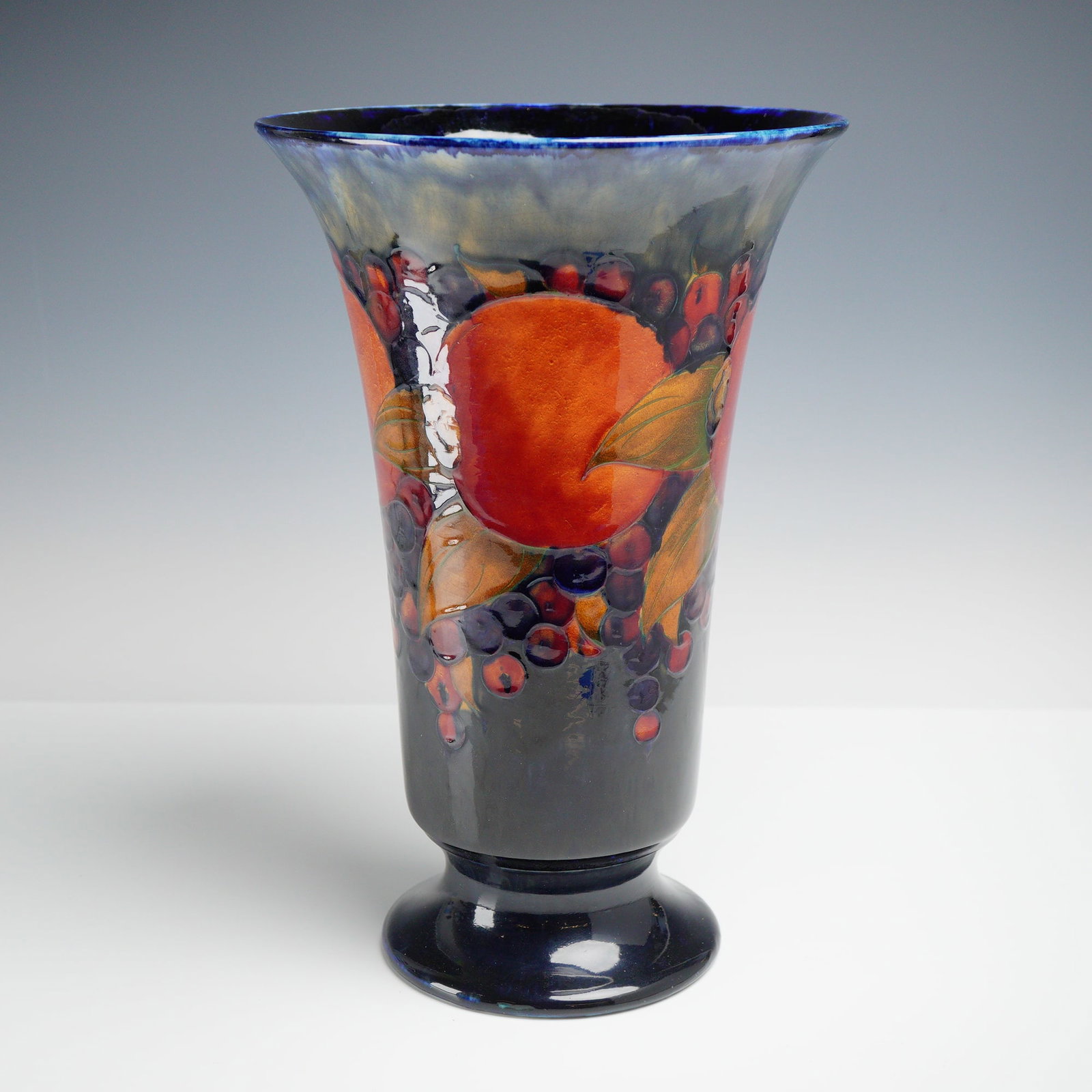 Moorcroft Large and Impressive Trumpet Vase, Pomegranate: Large trumpet vase in the 'Pomegranate' pattern, with green signature and impressed marks to the underside. Dimensions: 8"W x 12.25"H Manufacturer or Brand: Moorcroft Country of Origin: England Weight