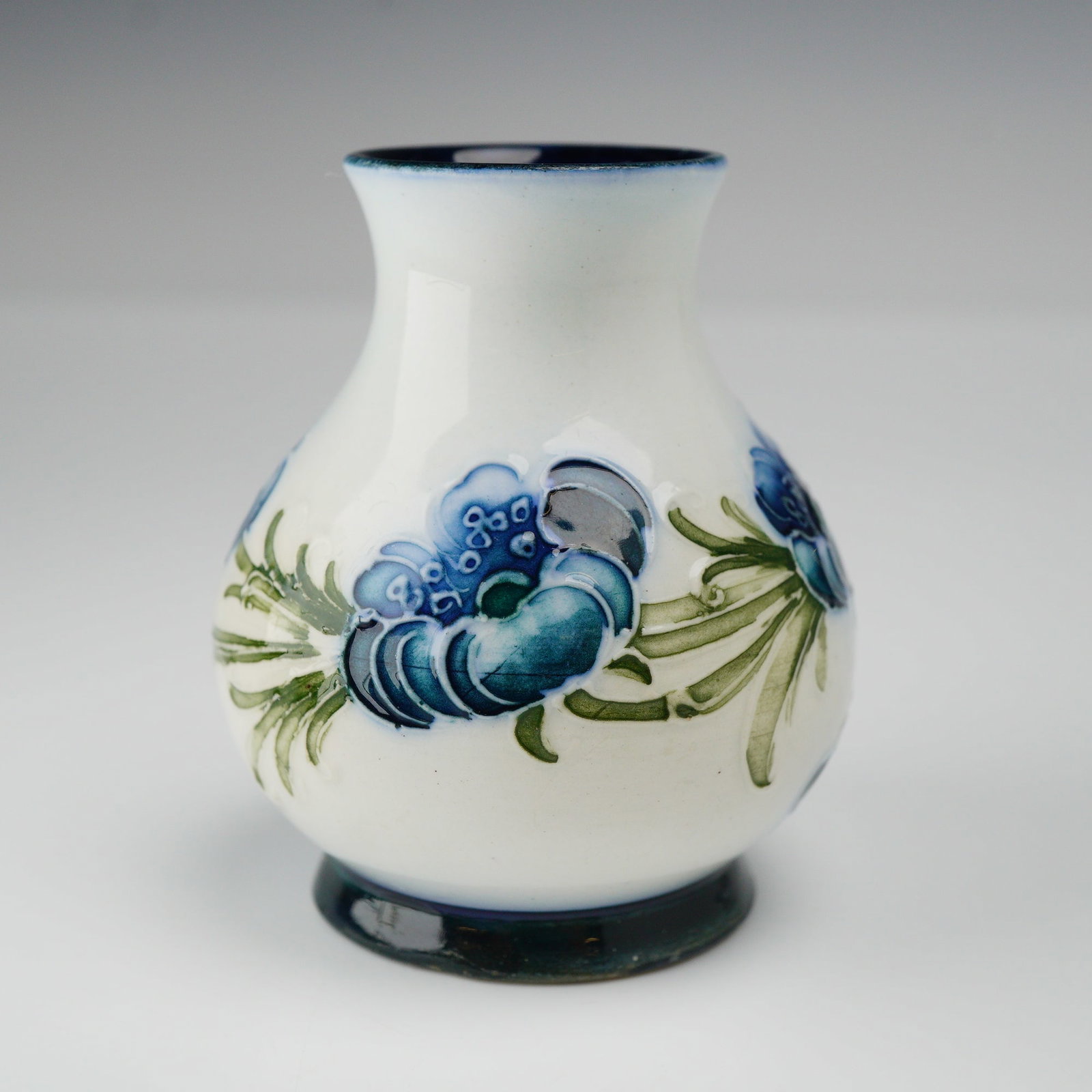 William Moorcroft for James MacIntyre Miniature Vase, Poppy Garland: William Moorcroft for James MacIntyre miniature Poppy Garland vase, circa 1903, baluster form, with printed mark and underglaze green monogram to the base. Dimensions: 2"W x 2.5"H Date or Era: c. 1903