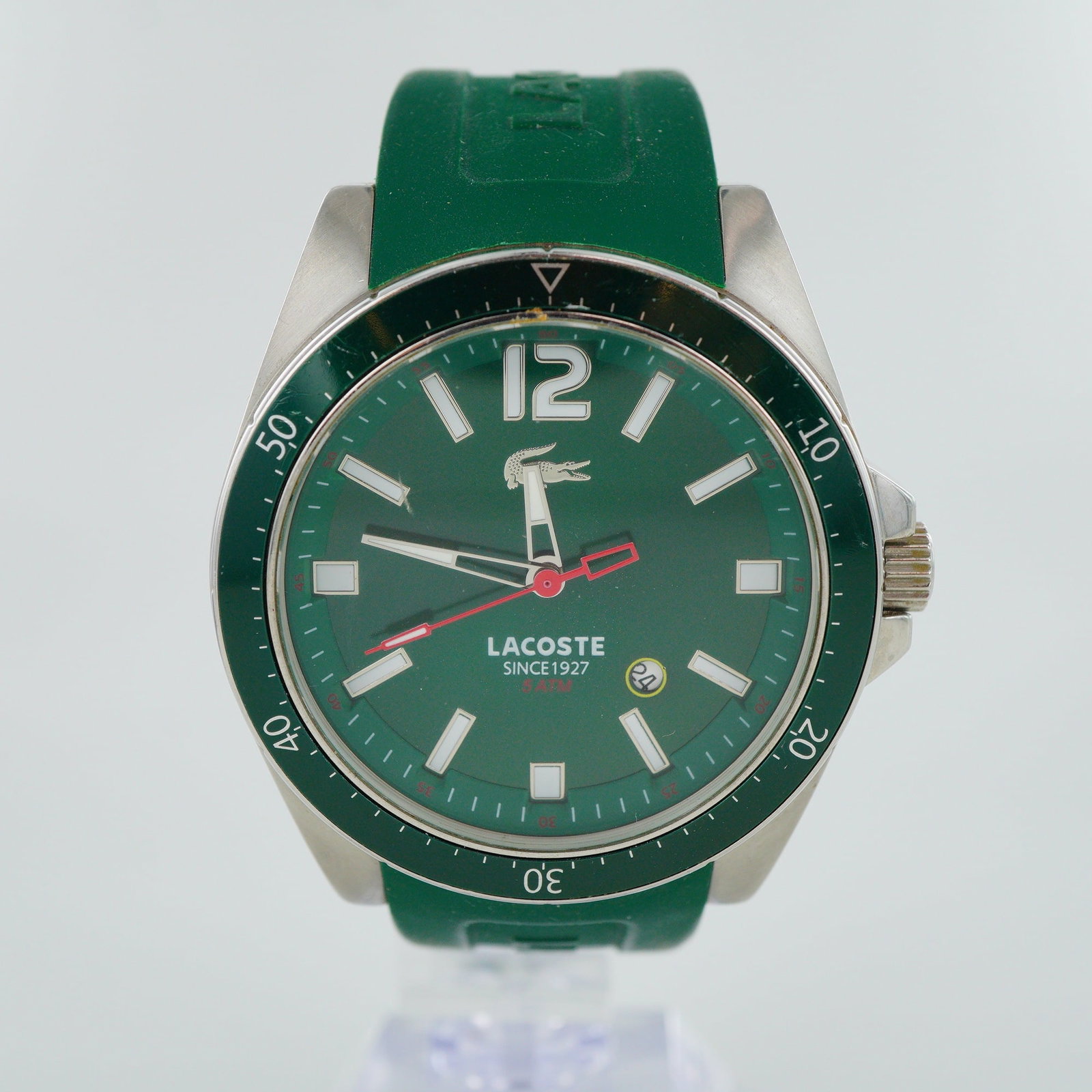 Lacoste Seattle Stainless Steel Quartz Wristwatch: This Lacoste Seattle wristwatch features a quartz movement housed within a stainless steel case. The design includes a green unidirectional rotating bezel with a 60-minute scale and a matching green d