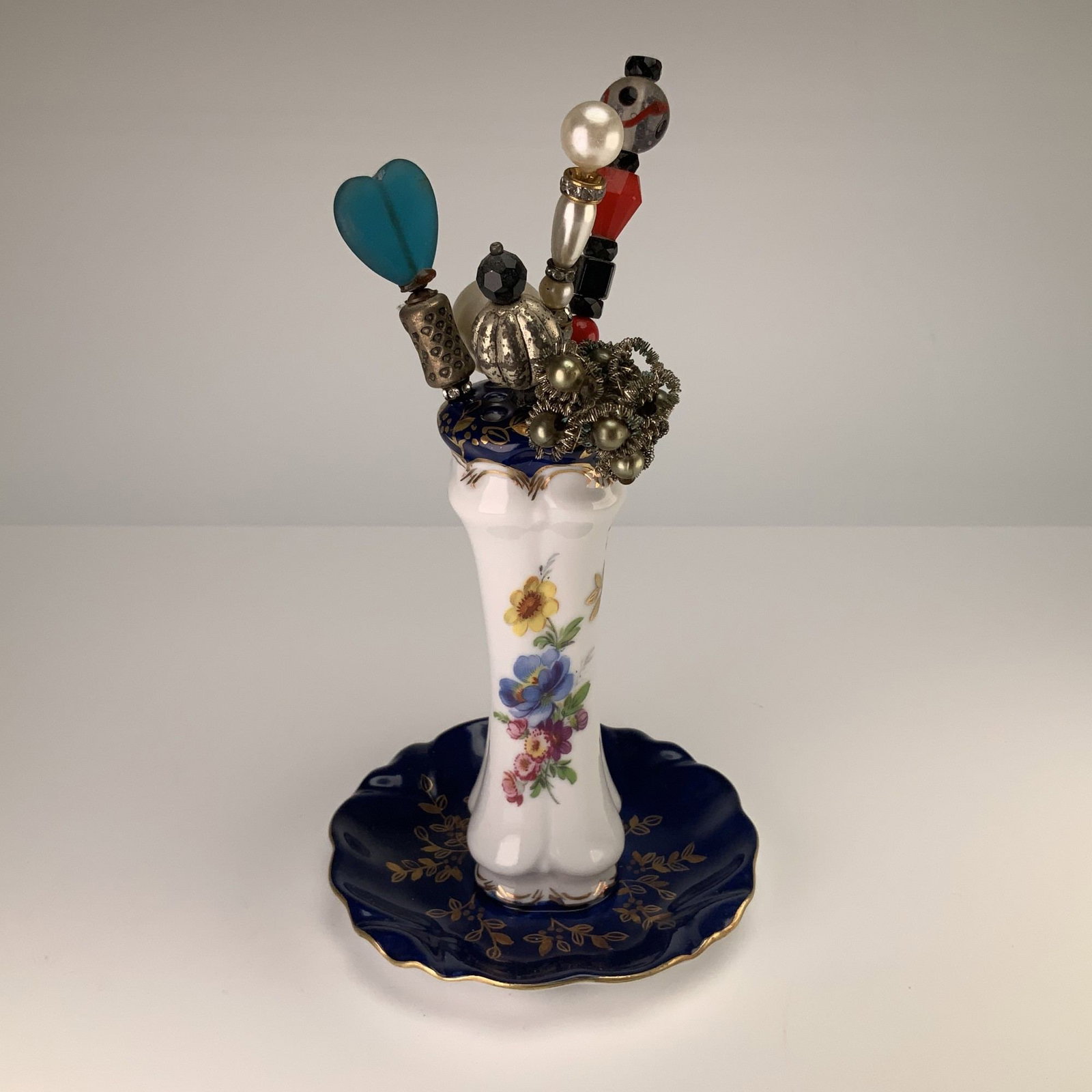 7pc Limoges France Hat Pin Holder and Hat Pins: This 7-piece set features a porcelain hatpin holder manufactured in Limoges, France, accompanied by a collection of six assorted hatpins and hair accessories. The holder is designed with a slender col