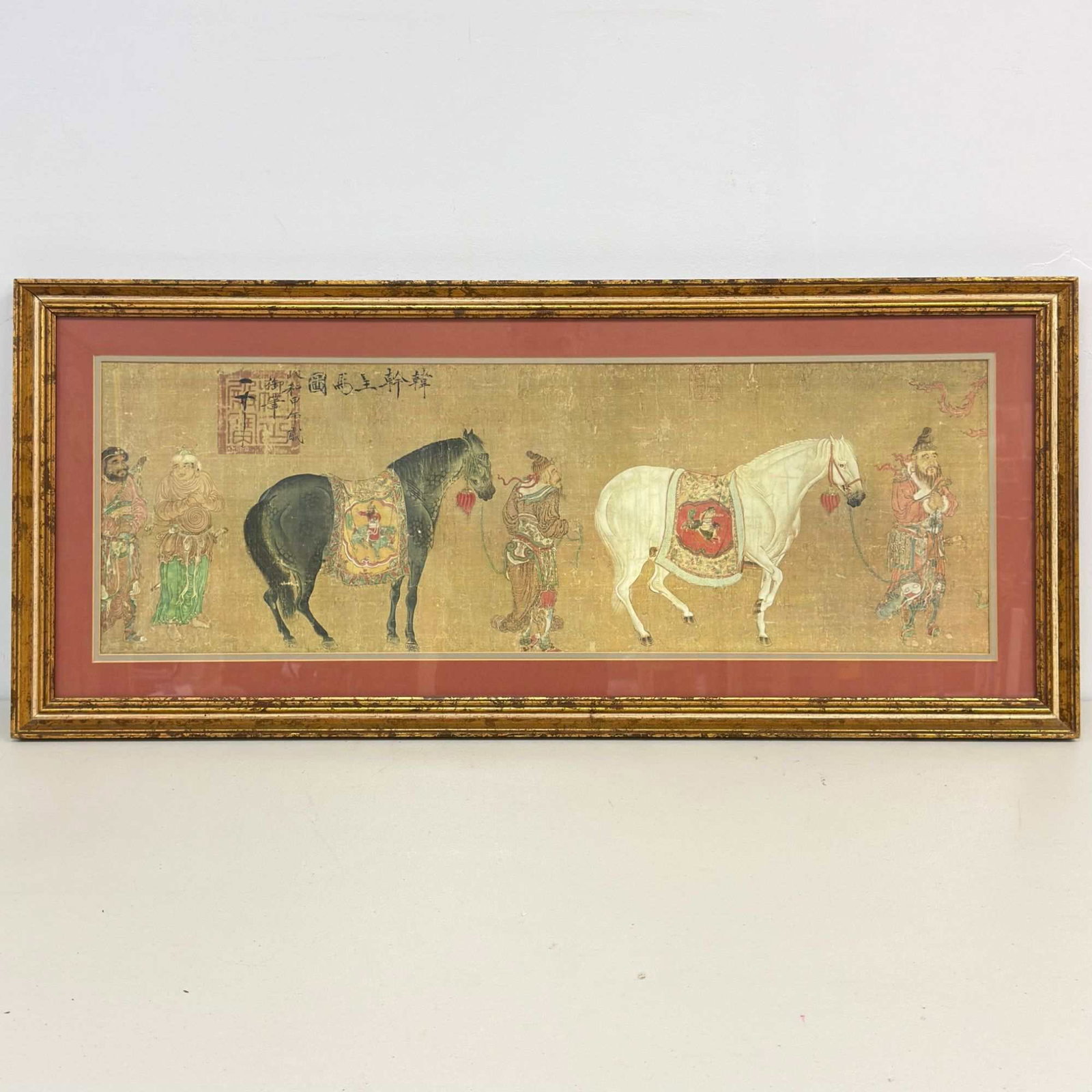 Framed Art Print on Paper Titled Tartars Bringing a Tribute of Horses after Han Kan: This item is a print on paper titled Tartars Bringing a Tribute of Horses after the Tang dynasty master Han Kan, also known as Han Gan. The horizontal composition depicts four figures in traditional a