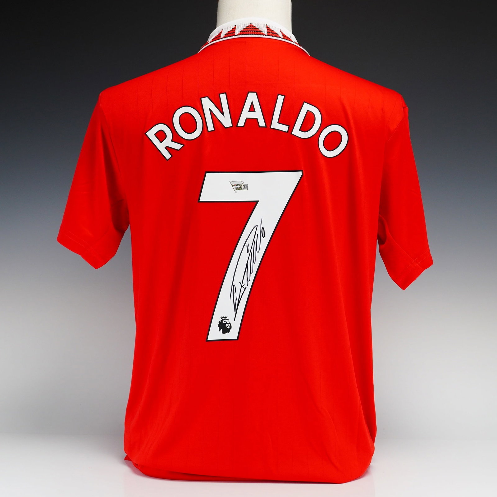Cristiano Ronaldo Autographed Manchester United 2022-2023 Adidas Home Jersey with Fanatics Authentic: This is a short-sleeved Manchester United home jersey manufactured by Adidas for the 2022-2023 season. The red jersey is constructed with a white polo collar featuring a distinctive red and black geom