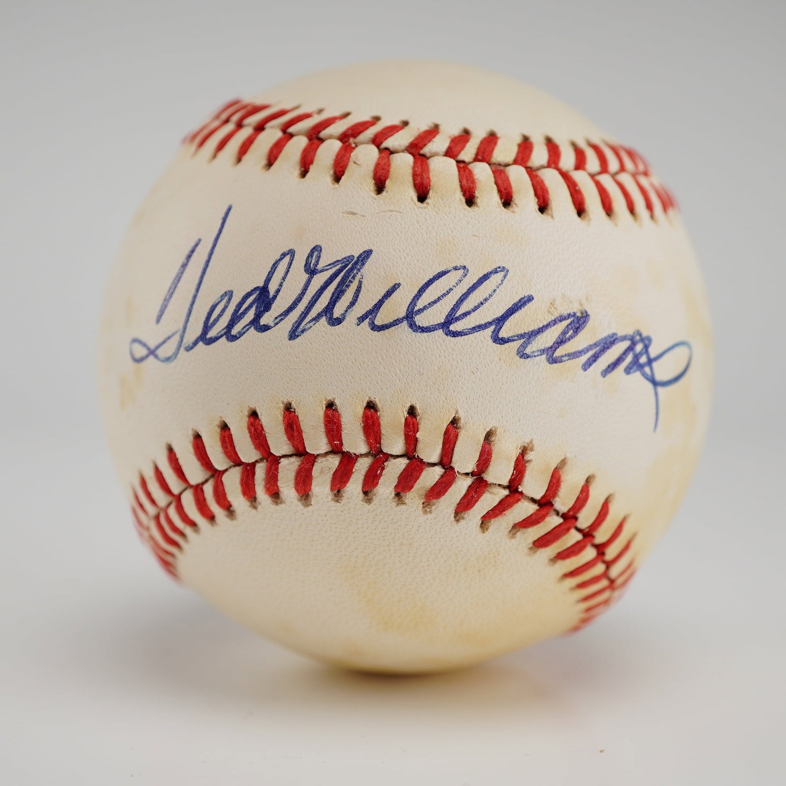Ted Williams Autographed Rawlings Official American League Baseball, PSA Authenticated: This lot features a premier piece of sports memorabilia: a single-signed baseball by Boston Red Sox legend and Hall of Famer, Ted Williams. The signature, executed in bold blue ink, is prominently dis