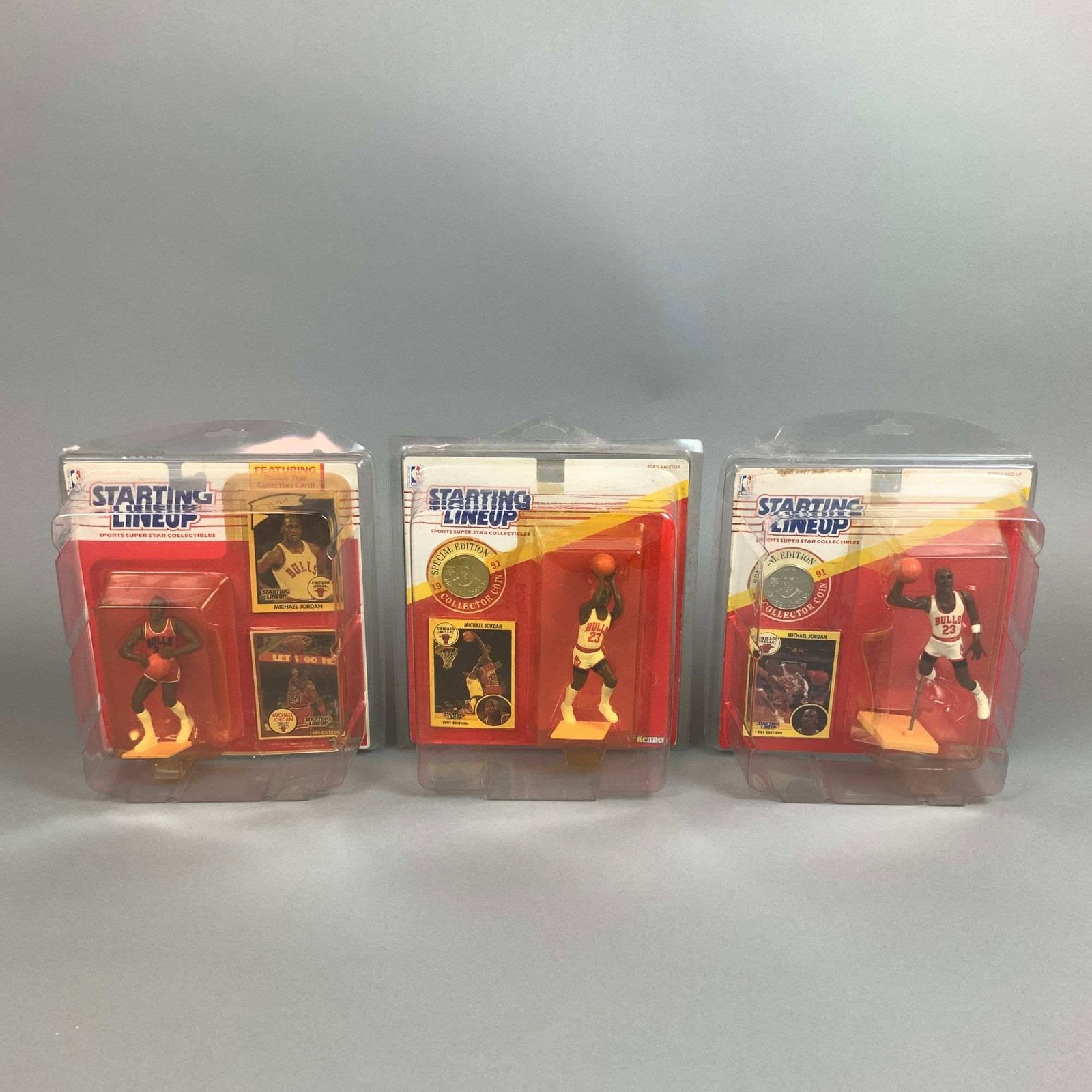 Three Kenner Starting Lineup NBA Action Figures, Michael Jordan: A trio of vintage Michael Jordan Starting Lineup action figures produced by Kenner for the NBA Sports Super Star Collectibles line. The collection includes one 1990 Edition figure and two 1991 Edition
