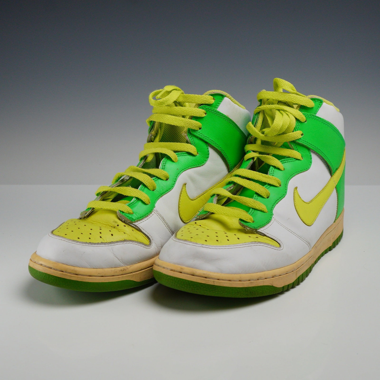 Pair of Nike Dunk High Premium Sneakers, Size 12: A pair of Nike Dunk High Premium sneakers in a white, lemon chiffon, and radiant green colorway, model number 309432-171. The high-top design features a white leather base with green leather overlays 