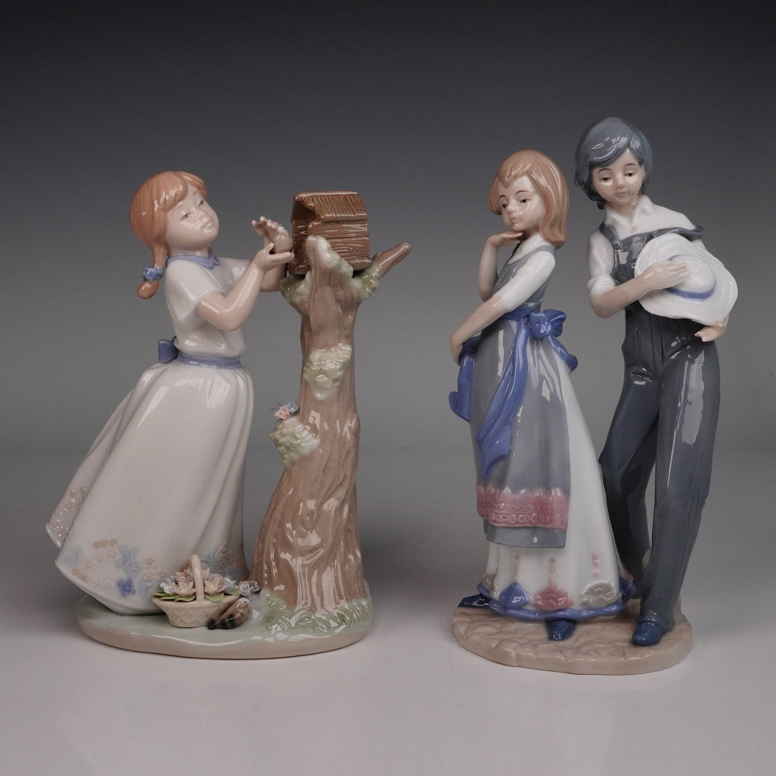A Pair of Glazed Ceramic Figurines, one by Nadal, depicting children: A pair of Spanish glazed ceramic figurines. The first figurine, marked 'NADAL' with a crown logo, 'MADE IN SPAIN,' and 'LIMITED EDITION N? 1344 / 5000,' depicts a young girl with reddish-brown pigtail
