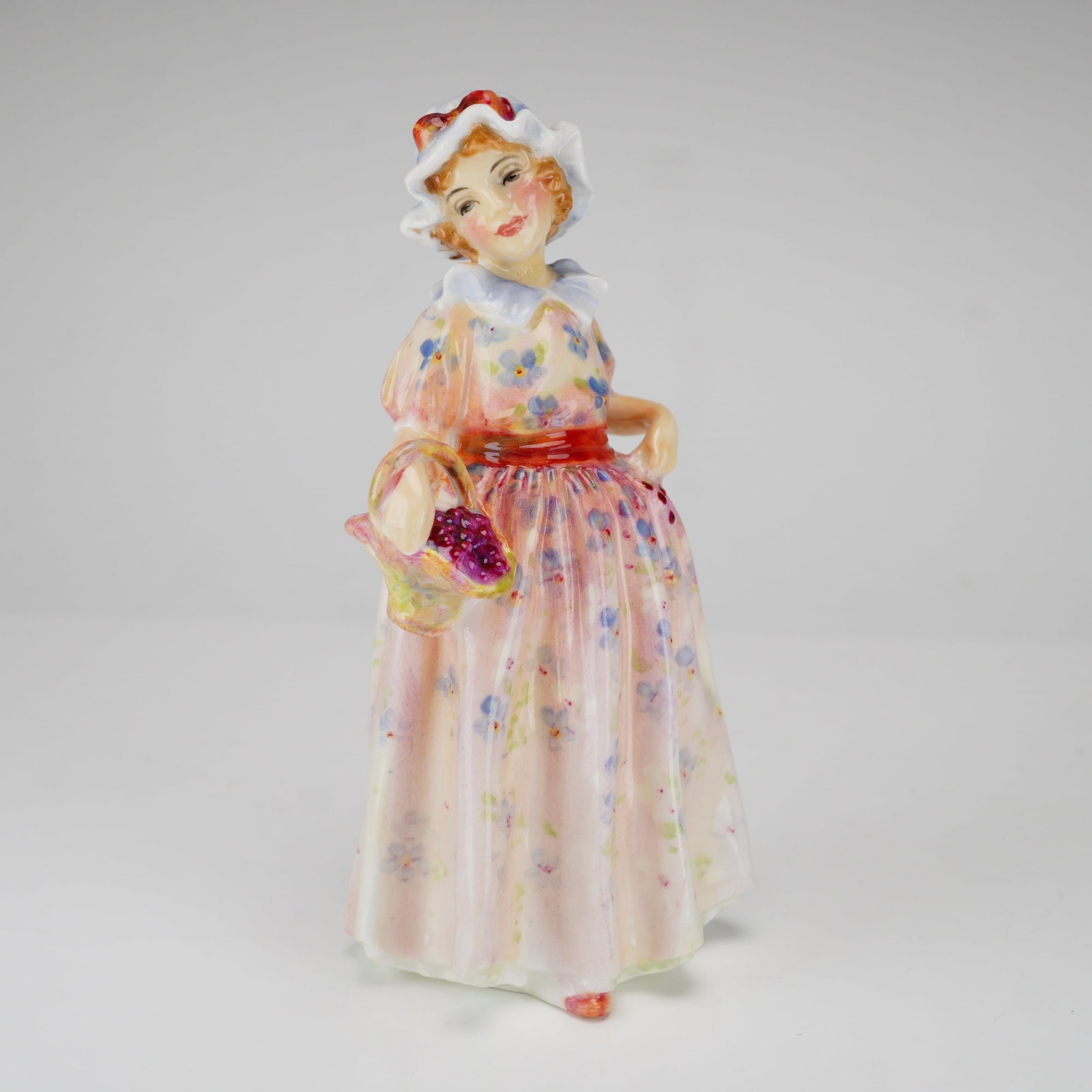Royal Doulton Figurine, Cerise HN1607: Leslie Harradine Young figure dressed in pink, cream and floral print dress. Royal Doulton backstamp. Dimensions: 5.75"H Date or Era: 1933 - 1949 Manufacturer or Brand: Royal Doulton Country of Origin