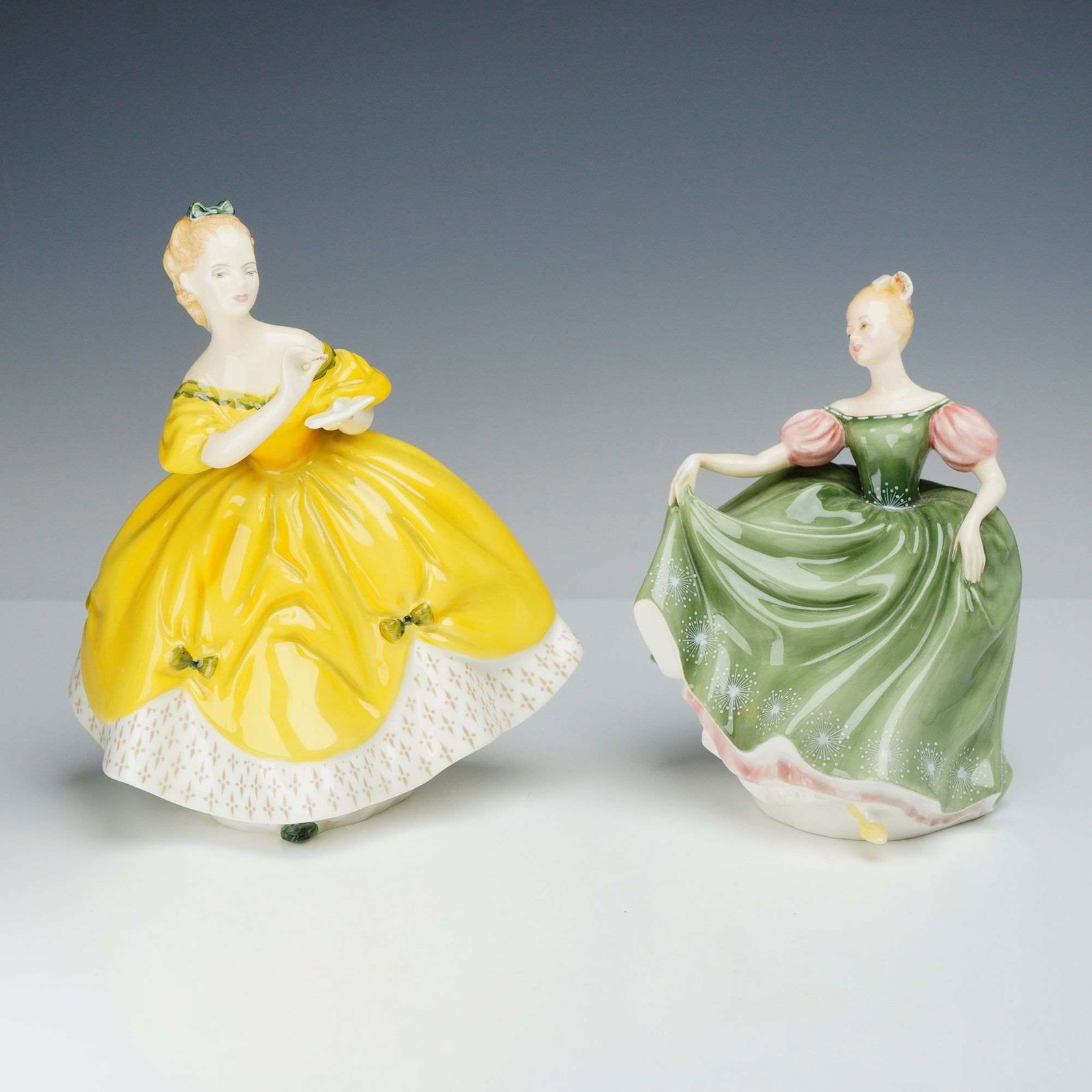 Two Royal Doulton Bone China Figurines, The Last Waltz HN 2315 and Michele HN 2234: A pair of hand-painted glazed bone china figurines manufactured by Royal Doulton. The first figurine, titled The Last Waltz (HN 2315), depicts a woman in a yellow off-the-shoulder gown with green ribb