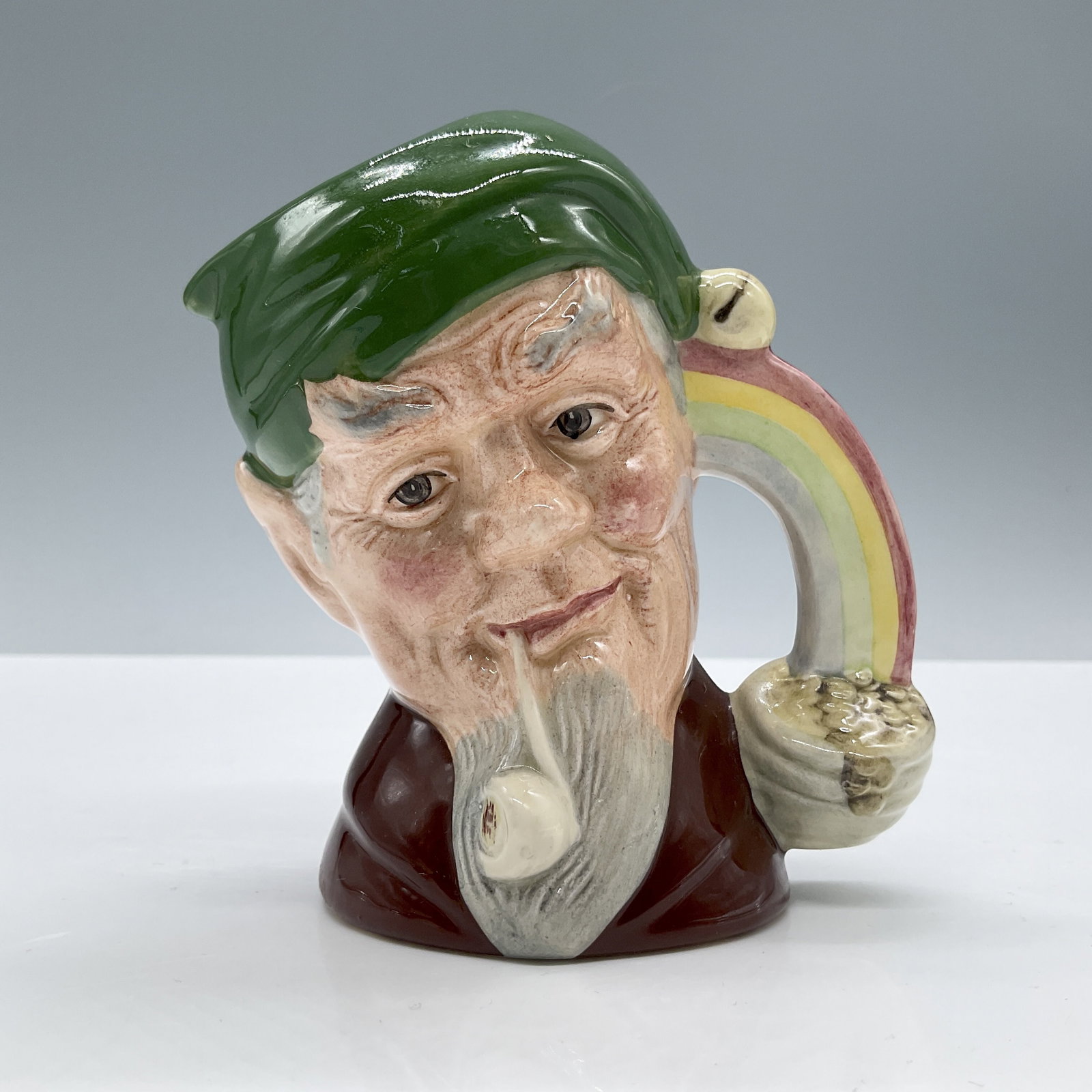 Leprechaun D6899 - Small - Royal Doulton Character Jug: Green cap; brown coat. Royal Doulton backstamp. Artist: William K. Harper Dimensions: 4.5"H Date or Era: 1991 - 1996 Manufacturer or Brand: Royal Doulton Country of Origin: England