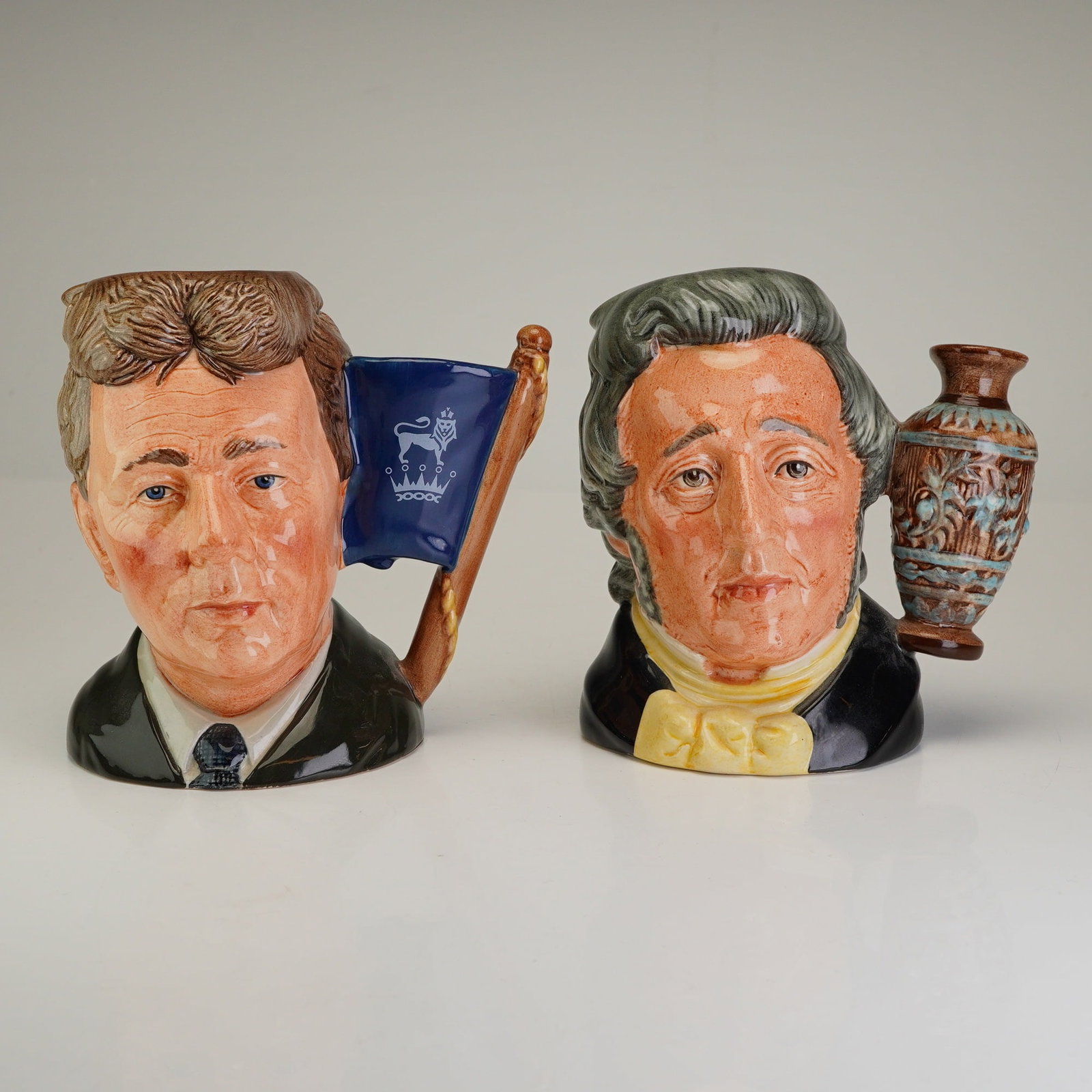 2pc Royal Doulton Small Character Jugs, Michael Doulton and Sir Henry Doulton: This lot features two small Royal Doulton character jugs honoring important figures in the company's history. The first is the Michael Doulton D6808 character jug, designed by William K. Harper and is