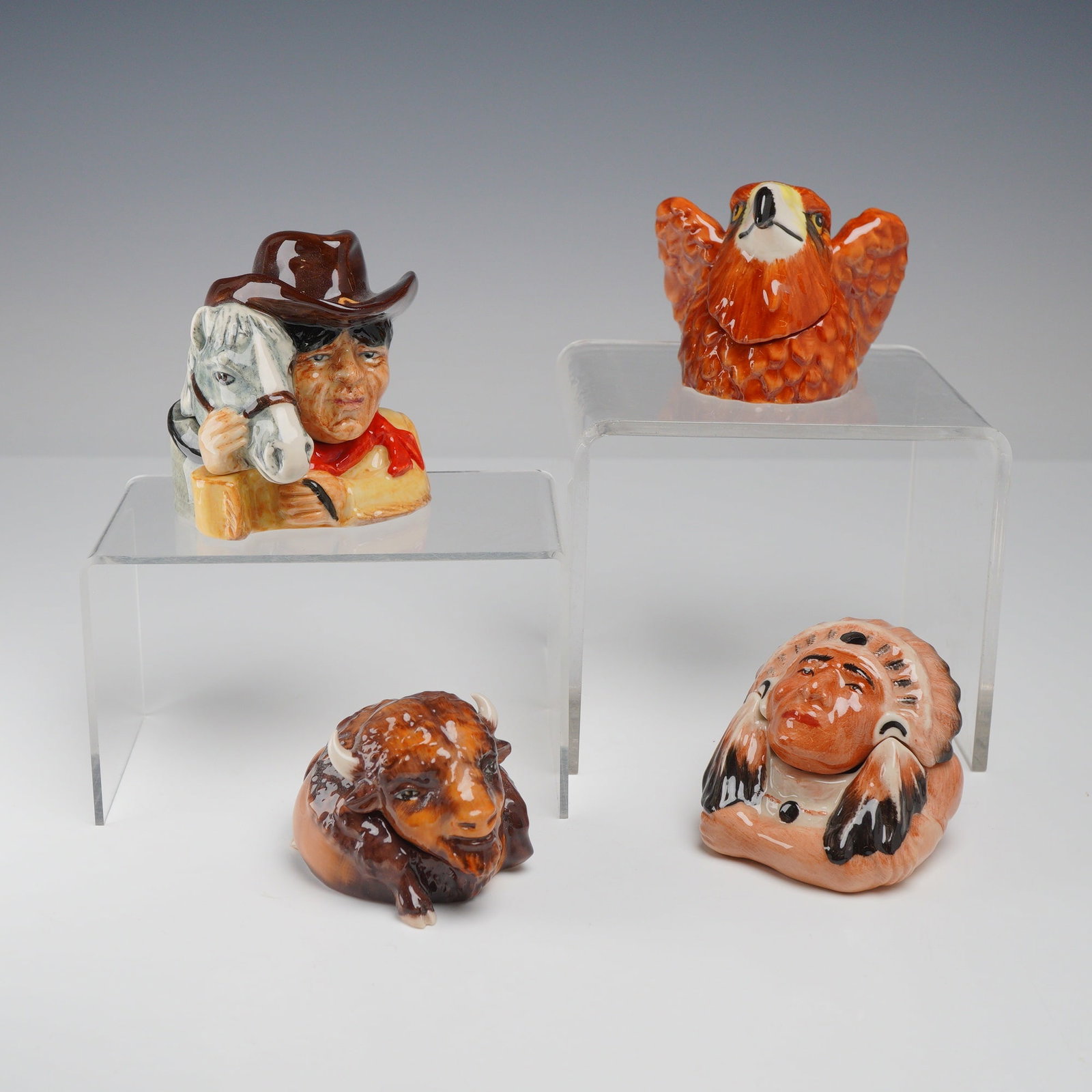 4pc Kevin Francis Face Pots, Western Theme Group: A group of four hand-painted glazed ceramic miniature lidded vessels, known as Face Pots, produced by Kevin Francis in England. Each pot features a themed lid and base with a unique interior inscripti