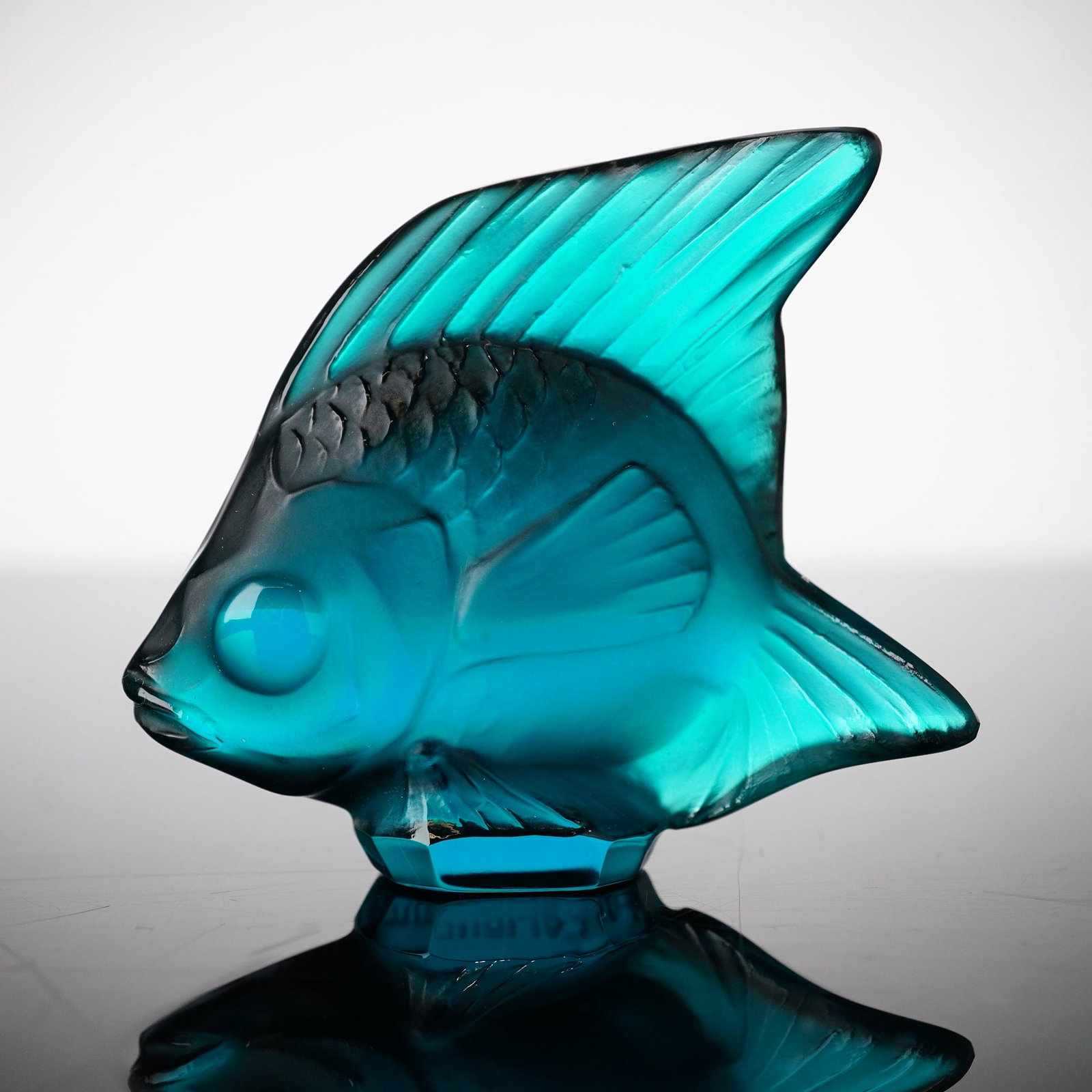 Lalique Crystal Turquoise Luster Fish Figurine: Fish sculpture colored in soft turquoise with signature frosted glass texture on the front and smooth crystal side. Imprinted Lalique on the bottom of the back. Dimensions: 2"L x 0.75"W x 1.75"H Date 