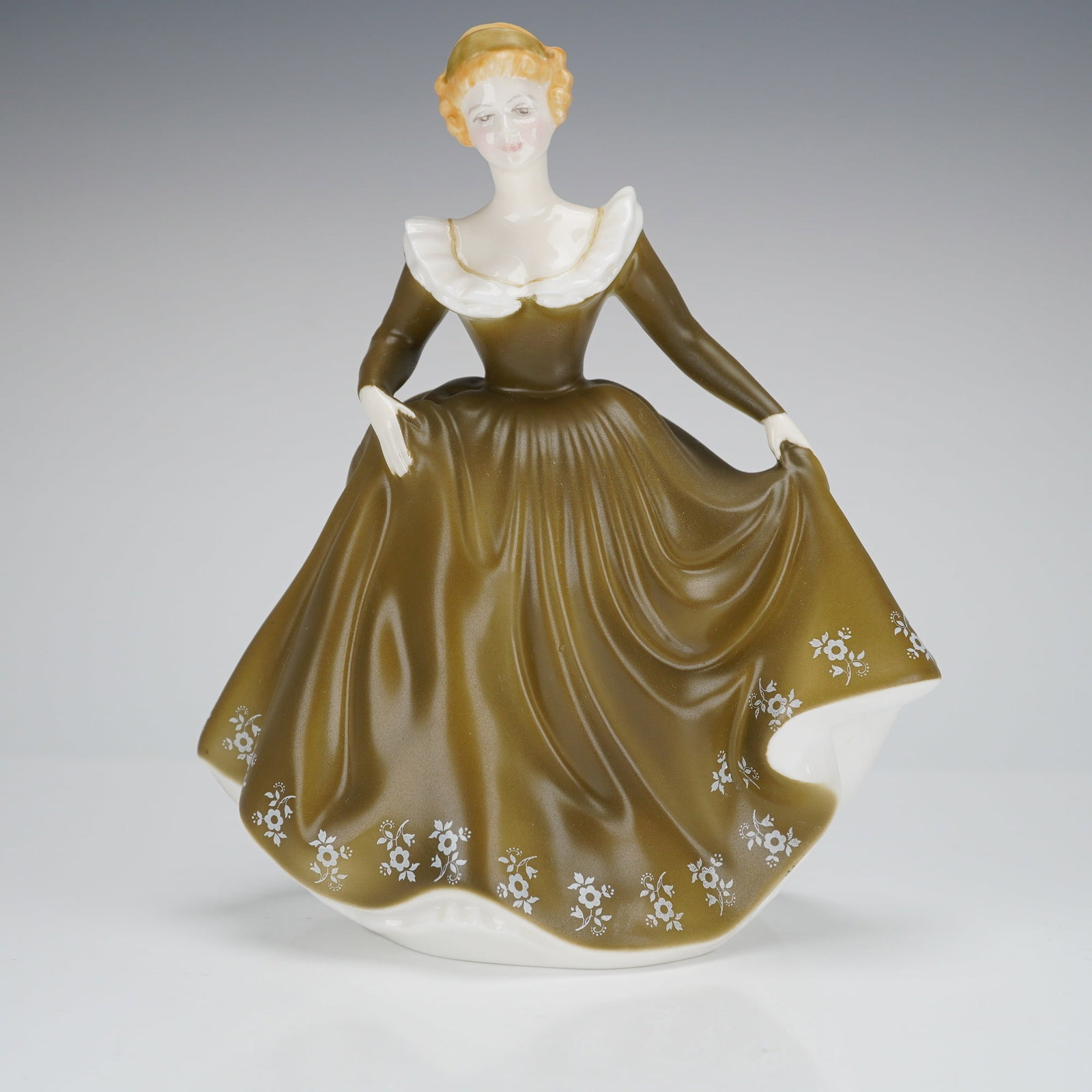 Royal Doulton Figurine Geraldine HN2348: A single Royal Doulton bone china figurine titled 'Geraldine,' model number HN2348. The figurine depicts a standing woman in a voluminous, romantic-era style gown finished in a glossy olive-green or d