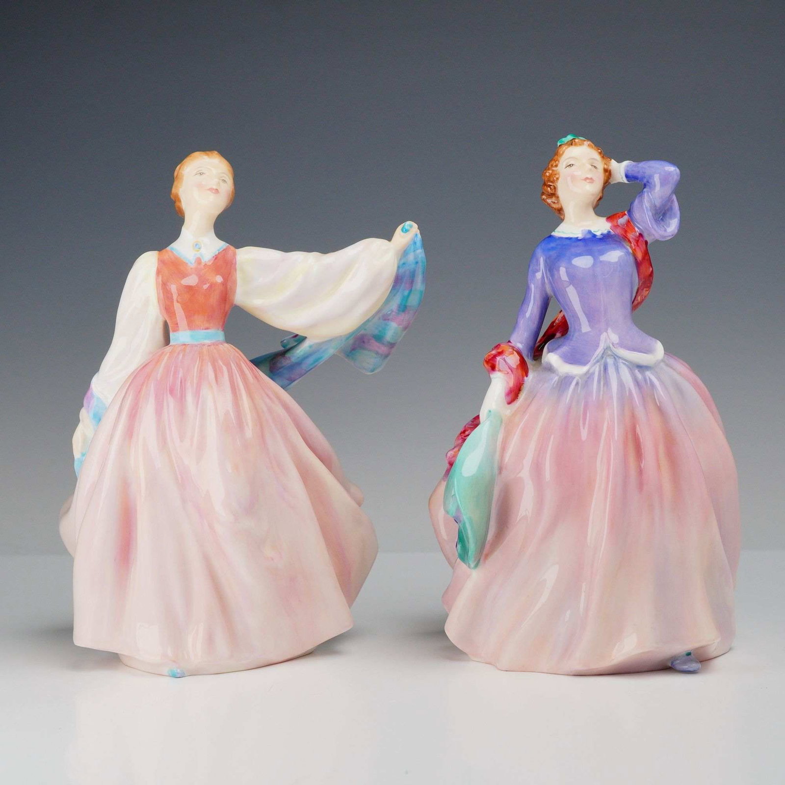 2pc Royal Doulton Bone China Figurines, Blithe Morning HN2021 and Gay Morning HN2135: This pair of hand-painted glazed bone china figurines was produced by Royal Doulton in England. The first figurine, identified as Gay Morning (model HN 2135), depicts a woman in a coral-colored bodice
