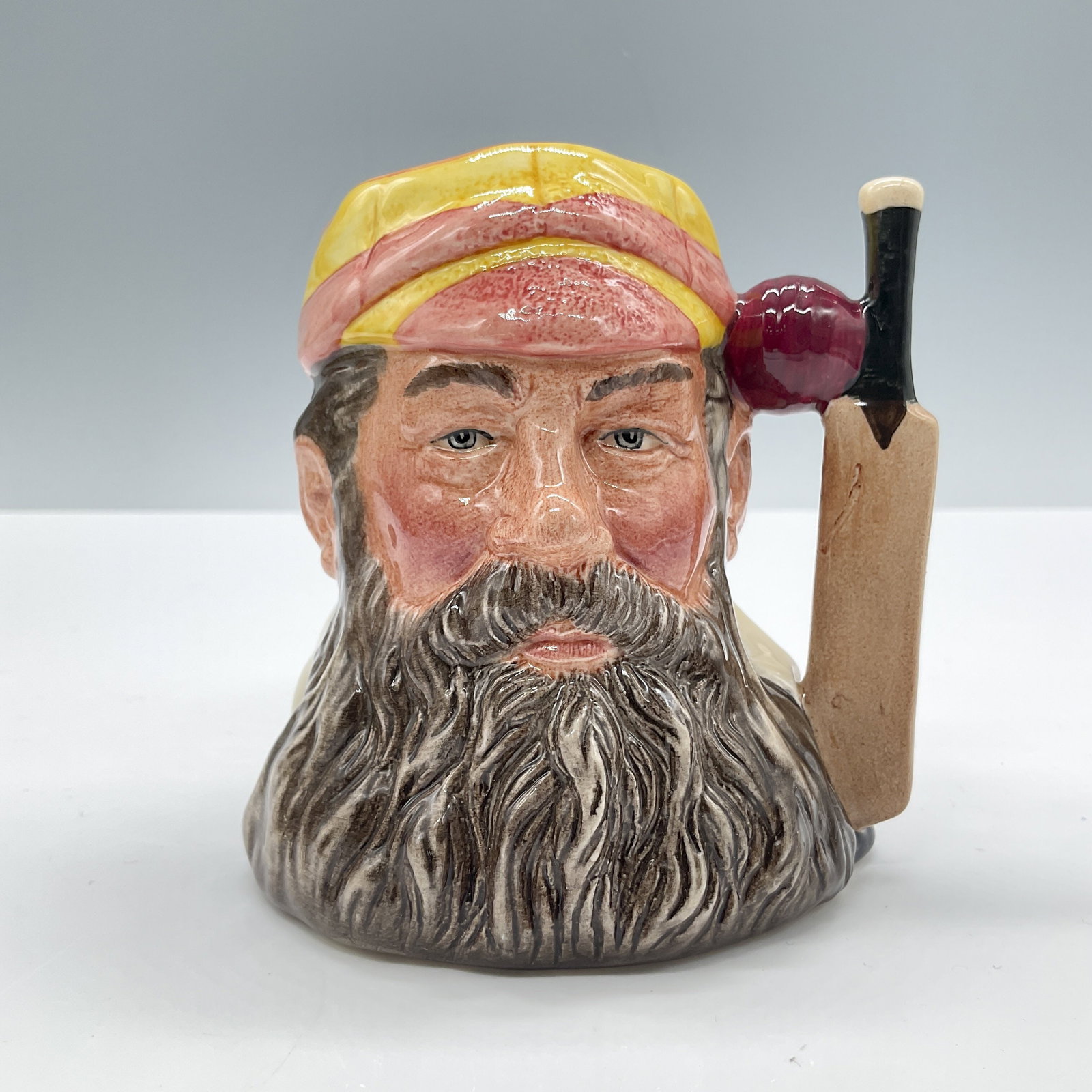 WG Grace D6845 - Small - Royal Doulton Character Jug: Yellow and orange striped cap; black beard. Limited edition. Royal Doulton backstamp. Artist: Stanley J. Taylor Dimensions: 3.25"H Date or Era: 1989 Edition Number and/or Size: 2009 of 9500 Manufa