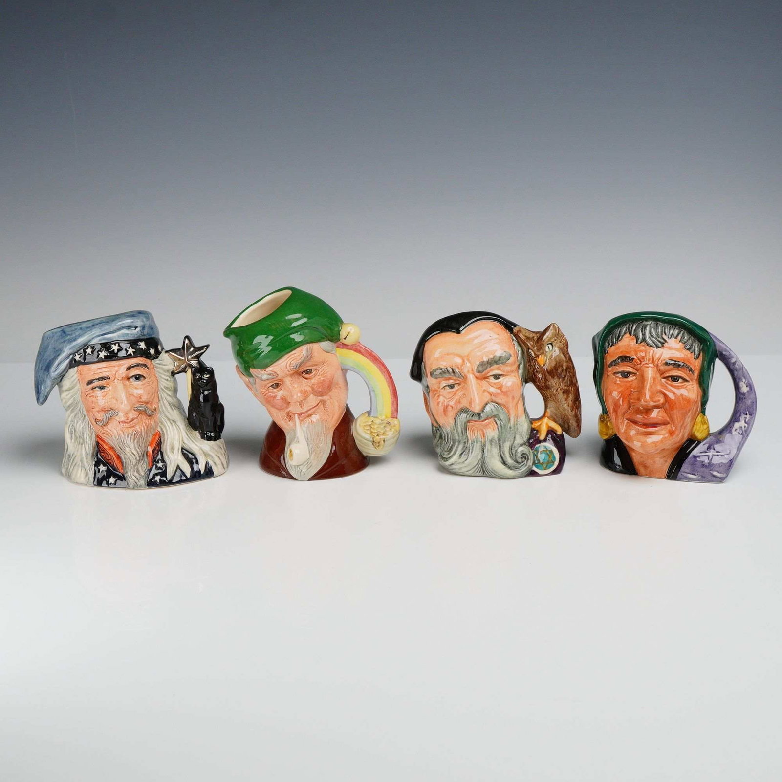 4pc Royal Doulton Character Jugs: This lot consists of four Royal Doulton glazed earthenware character jugs depicting folkloric and mystical figures. Each jug is decorated with hand-painted underglaze and overglaze colors and finished