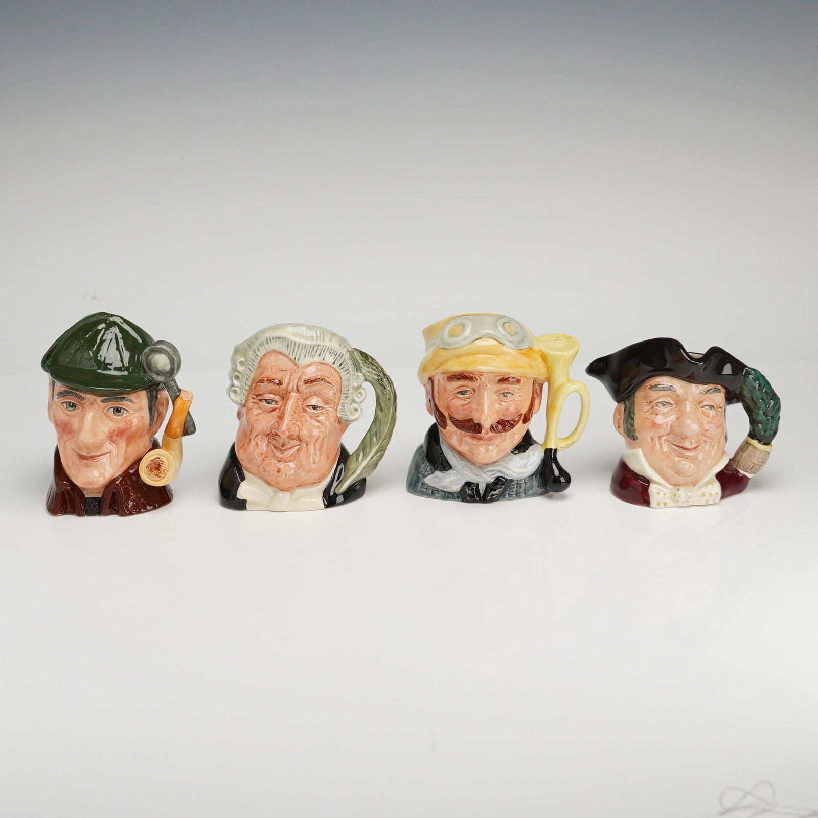 4pc Royal Doulton Character Jugs, The Sleuth, The Lawyer, Veteran Motorist, and Mine Host: This collection of Royal Doulton character jugs features several polychrome glazed ceramic figures, including Mine Host D6470, Veteran Motorist D6637, The Lawyer D6504, and The Sleuth D6635. Each piec