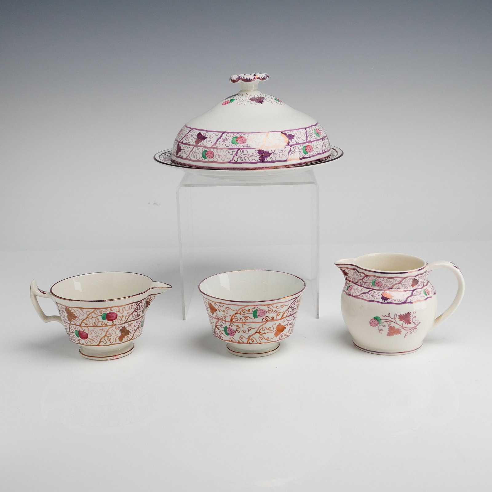 4pc Wedgwood Strawberry Lustre Open Sugar, Two Creamers, and Round Covered Butter Dish: This 4pc collection of Wedgwood fine earthenware features the Strawberry Lustre pattern. The group includes a round covered butter dish with a domed lid and floral finial, an open sugar bowl, and two 