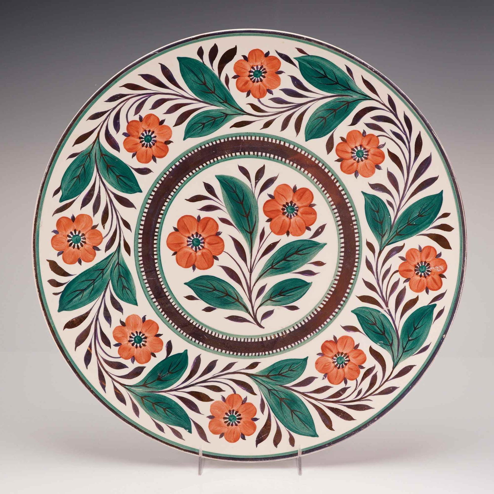 Wedgwood Hand-Painted Earthenware Charger in the Fleuri Royal Pattern: This large earthenware charger is decorated in the Fleuri Royal pattern, a design attributed to French Quimper faience. The hand-painted decoration features a central spray of orange flowers and green