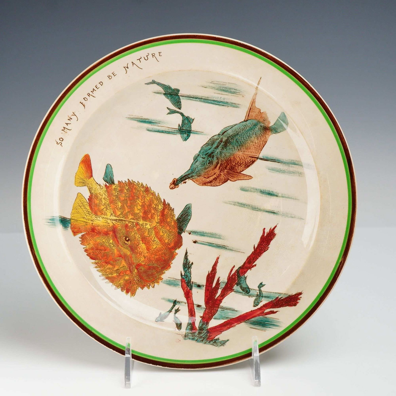 Wedgwood Chaucer Glazed Fish Theme Plate: This is a glazed earthenware plate from the Mottoes from Chaucer series by Wedgwood. The circular plate features a central marine scene depicting a large orange and yellow pufferfish, a blue and brown